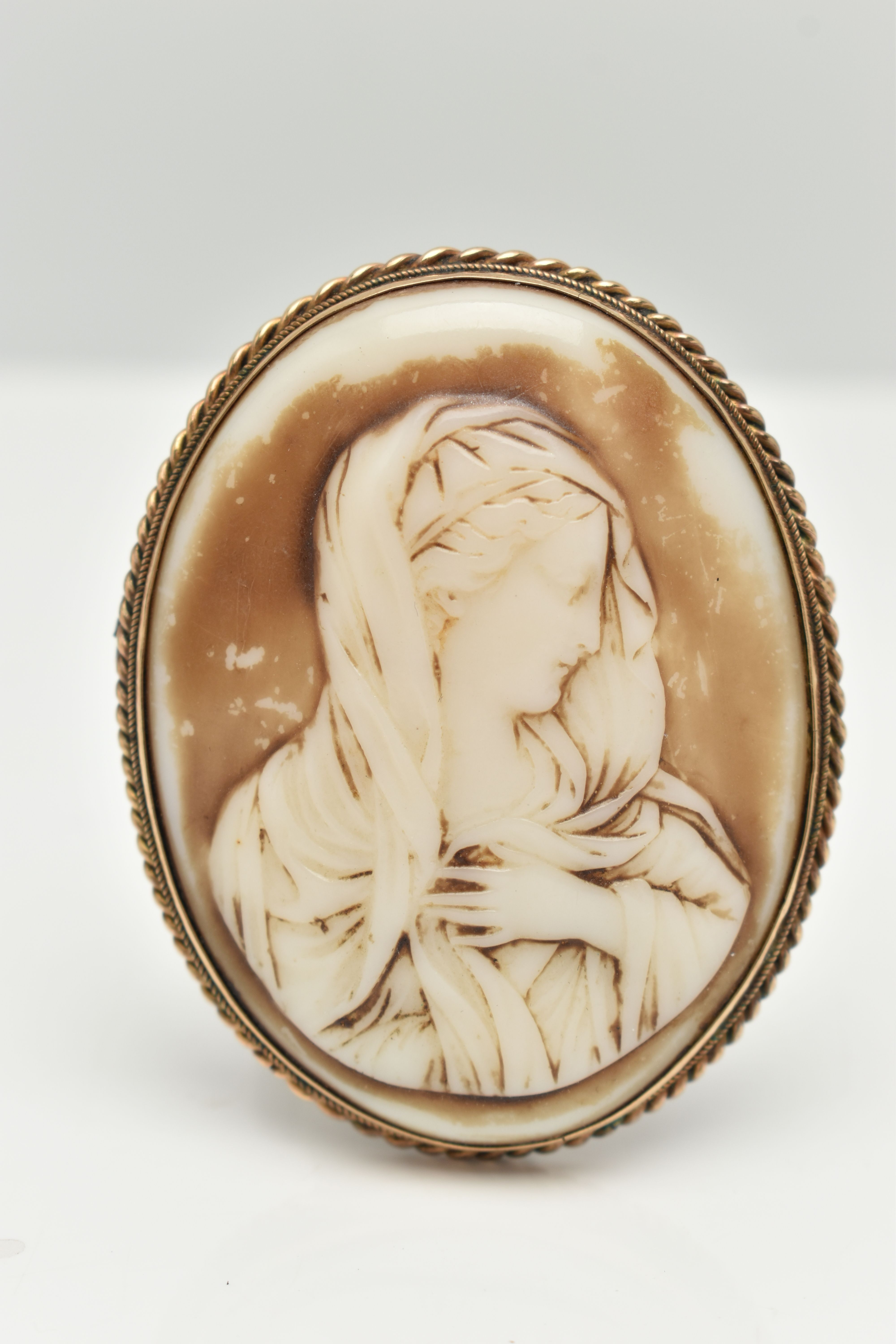 A LARGE YELLOW METAL CAMEO BROOCH, molded plastic, painted cameo possibly depicting Madonna,