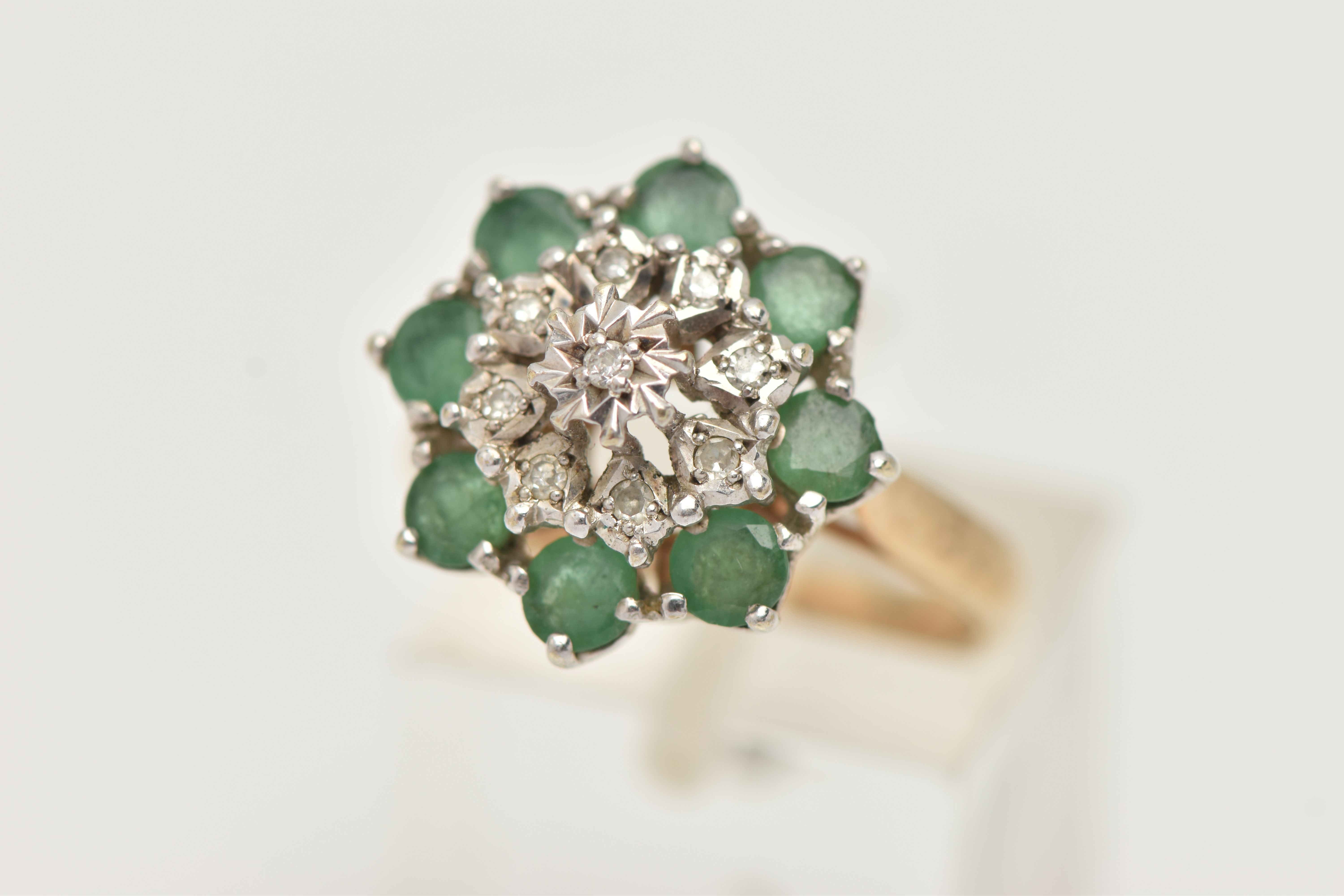 A 9CT GOLD EMERALD AND DIAMOND CLUSTER RING, tiered cluster set with nine illusion set single cut