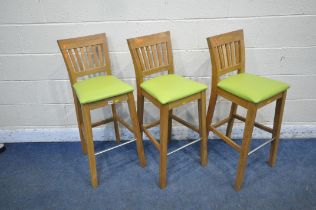 A SET OF THREE OAK BAR STOOLS, with a tubular metal footrest and lime green upholstery, width 37cm x