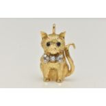 AN 18CT GOLD DIAMOND AND SAPPHIRE CAT PENDANT, the seated cat with sapphire eyes and a bow set