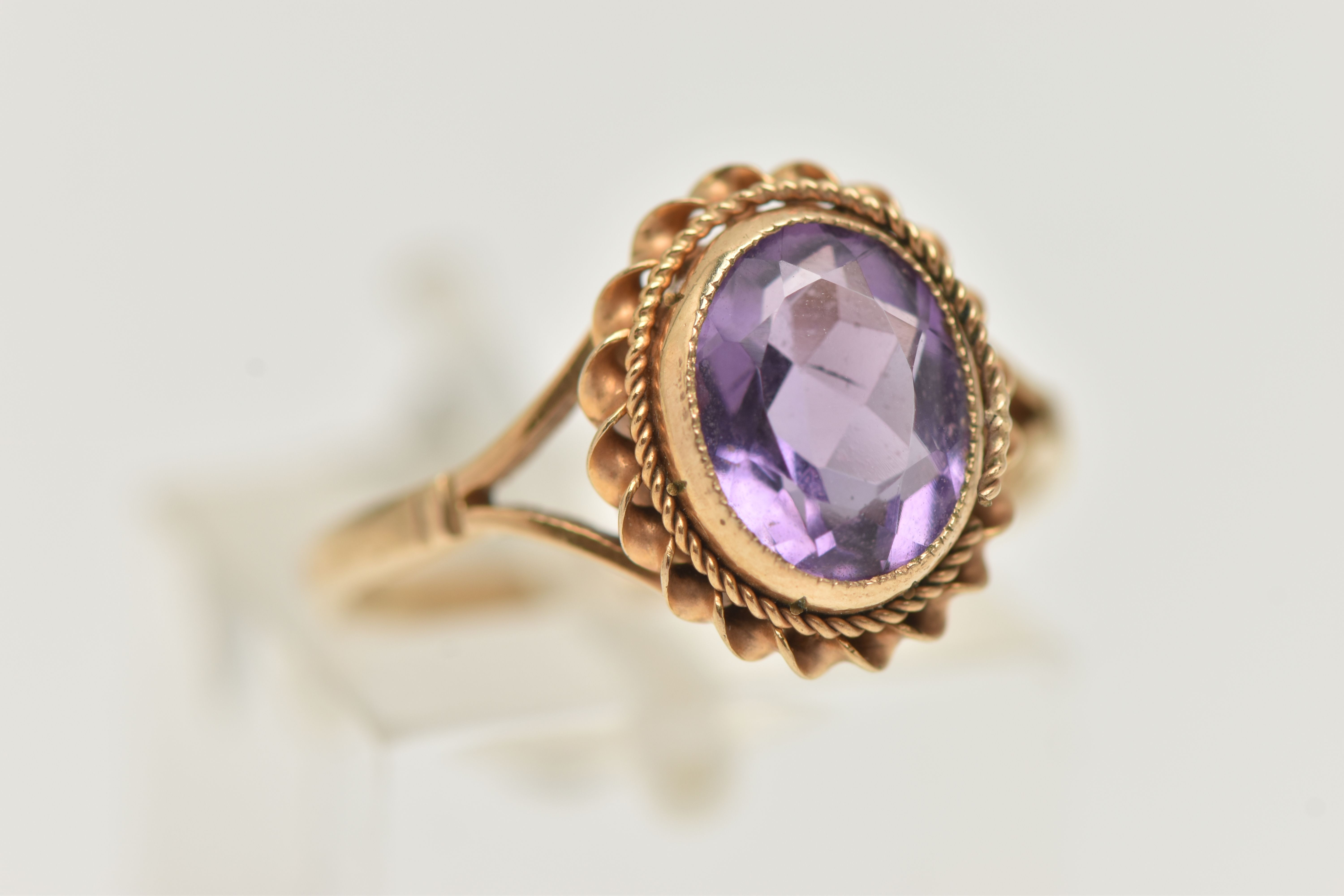 A 9CT GOLD AMETHYST RING, centering on an oval cut amethyst, collet set with a fine rope twist - Image 4 of 4