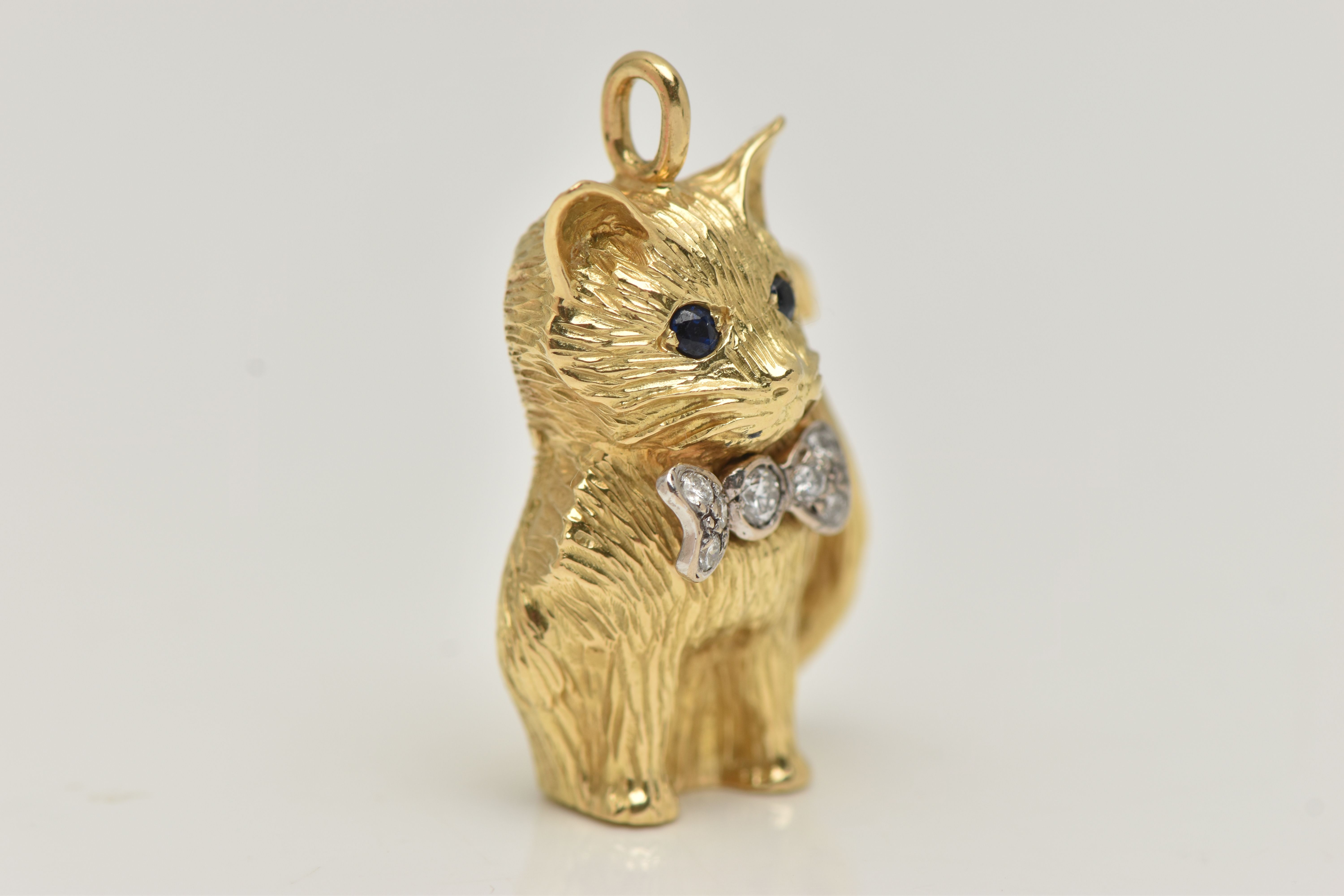 AN 18CT GOLD DIAMOND AND SAPPHIRE CAT PENDANT, the seated cat with sapphire eyes and a bow set - Image 2 of 5