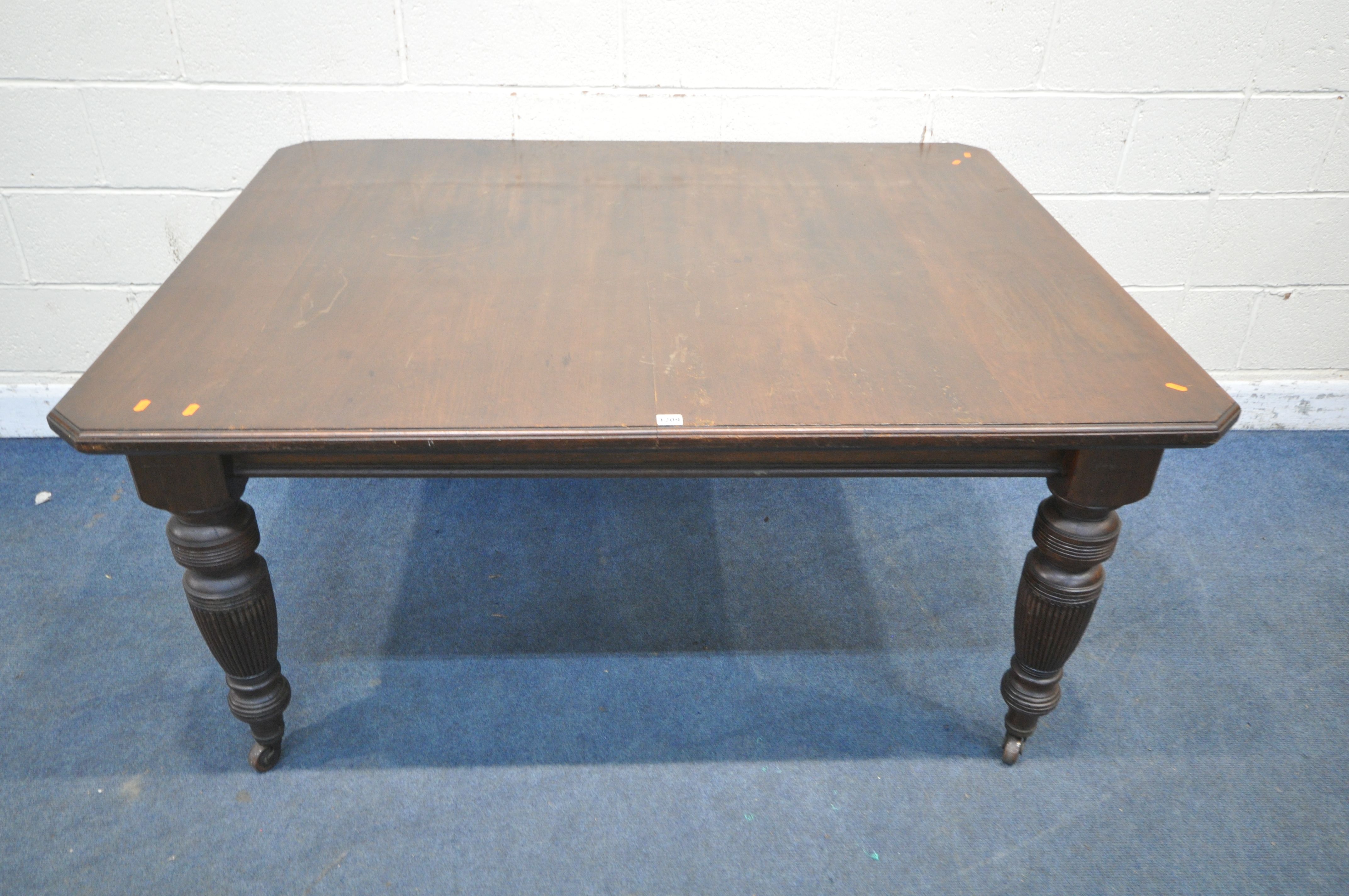 A VICTORIAN WIND OUT DINING TABLE, with canted corners, raised on turned and reeded legs, with