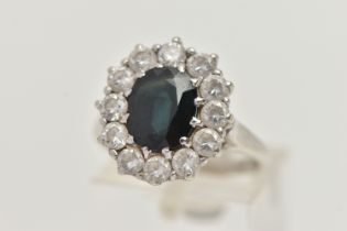 A 9CT GOLD SAPPHIRE RING, a principally set oval cut sapphire, with a surround of circular cut cubic