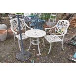 A CAST ALUMINIUM GARDEN TABLE 61cm in diameter, two matching chairs and parasol base (4)