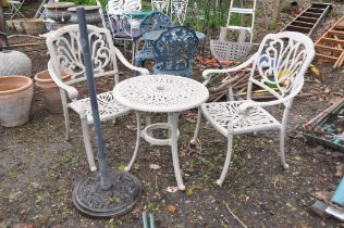 A CAST ALUMINIUM GARDEN TABLE 61cm in diameter, two matching chairs and parasol base (4)