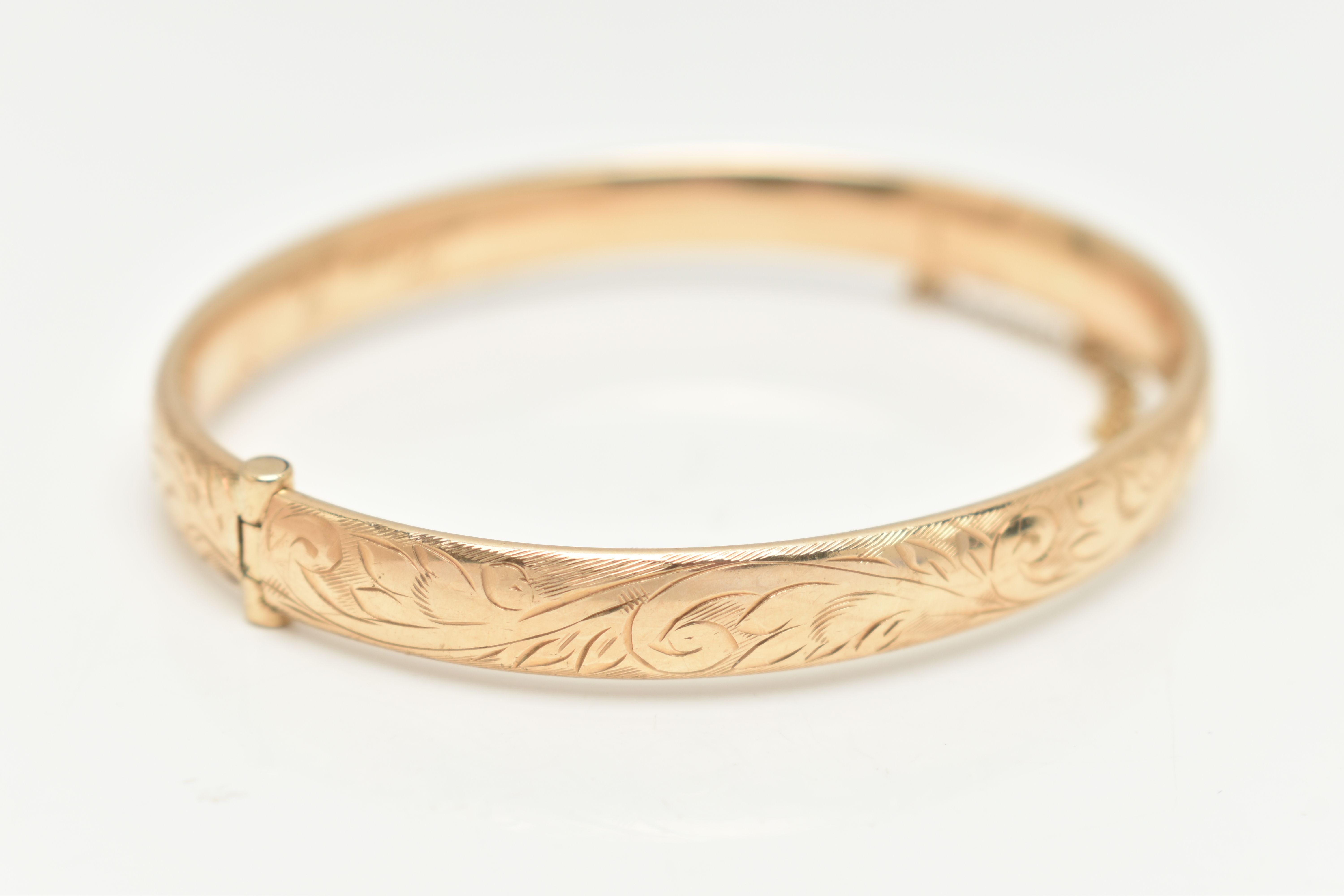 A 9CT GOLD HINGED BANGLE, with engraved scrolling acanthus decoration throughout to the hidden - Image 2 of 3