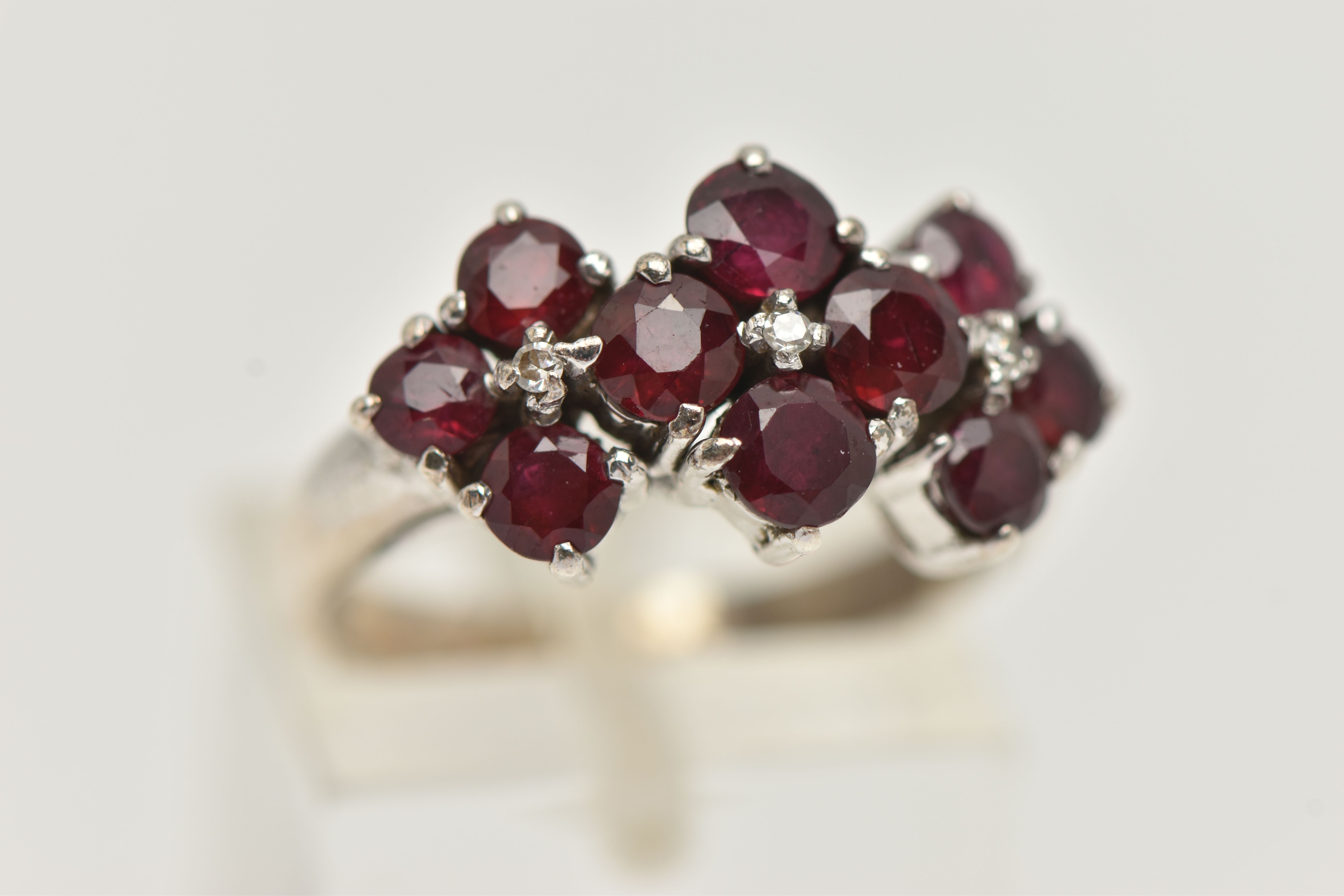 A WHITE METAL RUBY AND DIAMOND DRESS RING, set with ten circular cut rubies, each claw set, with - Image 4 of 4