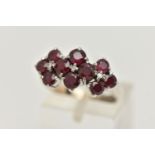 A WHITE METAL RUBY AND DIAMOND DRESS RING, set with ten circular cut rubies, each claw set, with