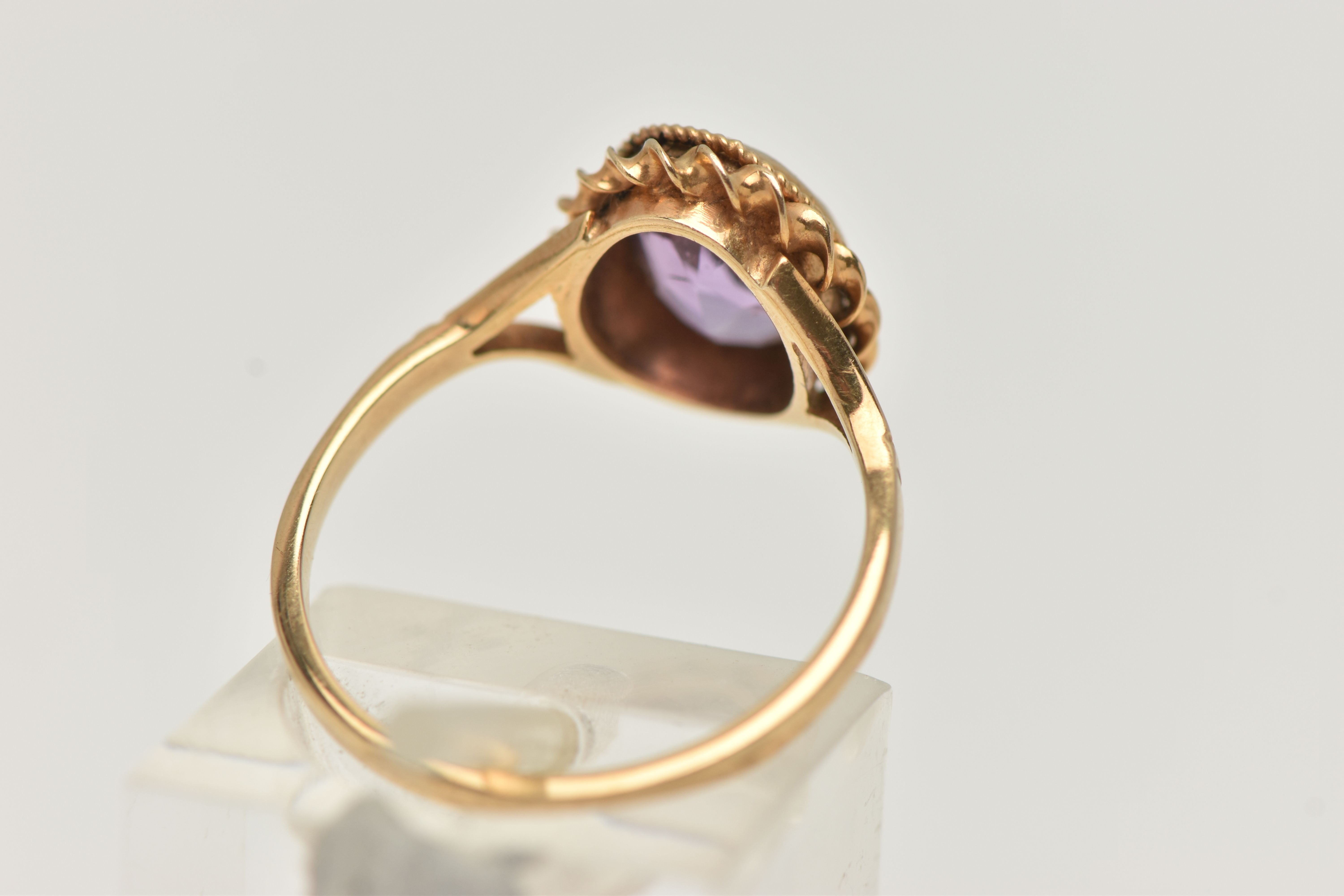 A 9CT GOLD AMETHYST RING, centering on an oval cut amethyst, collet set with a fine rope twist - Image 3 of 4
