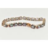 A 9CT GOLD MYSTIC TOPAZ LINE BRACELET, designed as a series of twenty-two oval cut, mystic coated