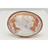 A LARGE YELLOW METAL CAMEO BROOCH, of an oval form, carved shell cameo depicting two ladies in