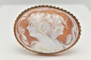 A LARGE YELLOW METAL CAMEO BROOCH, of an oval form, carved shell cameo depicting two ladies in