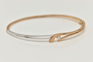 A MODERN 9CT YELLOW AND WHITE GOLD DIAMOND BANGLE, the hinged bangle set with a round brilliant-