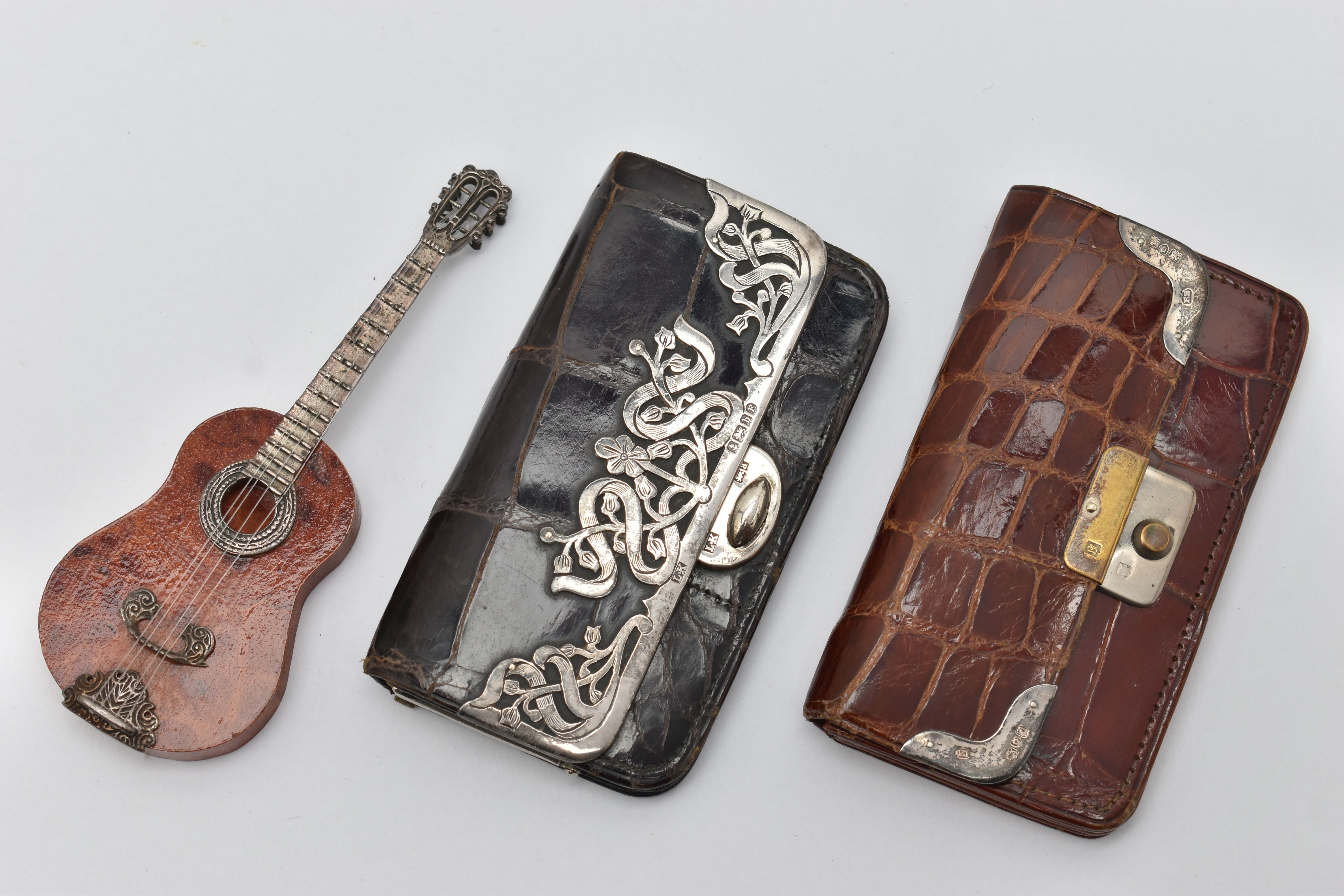 TWO SILVER MOUNTED PURSES AND A MINITURE GUITAR, the first a black croc purse with floral silver