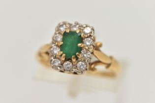 A YELLOW METAL EMERALD AND DIAMOND CLUSTER RING, of a rectangular form, set to the centre with an