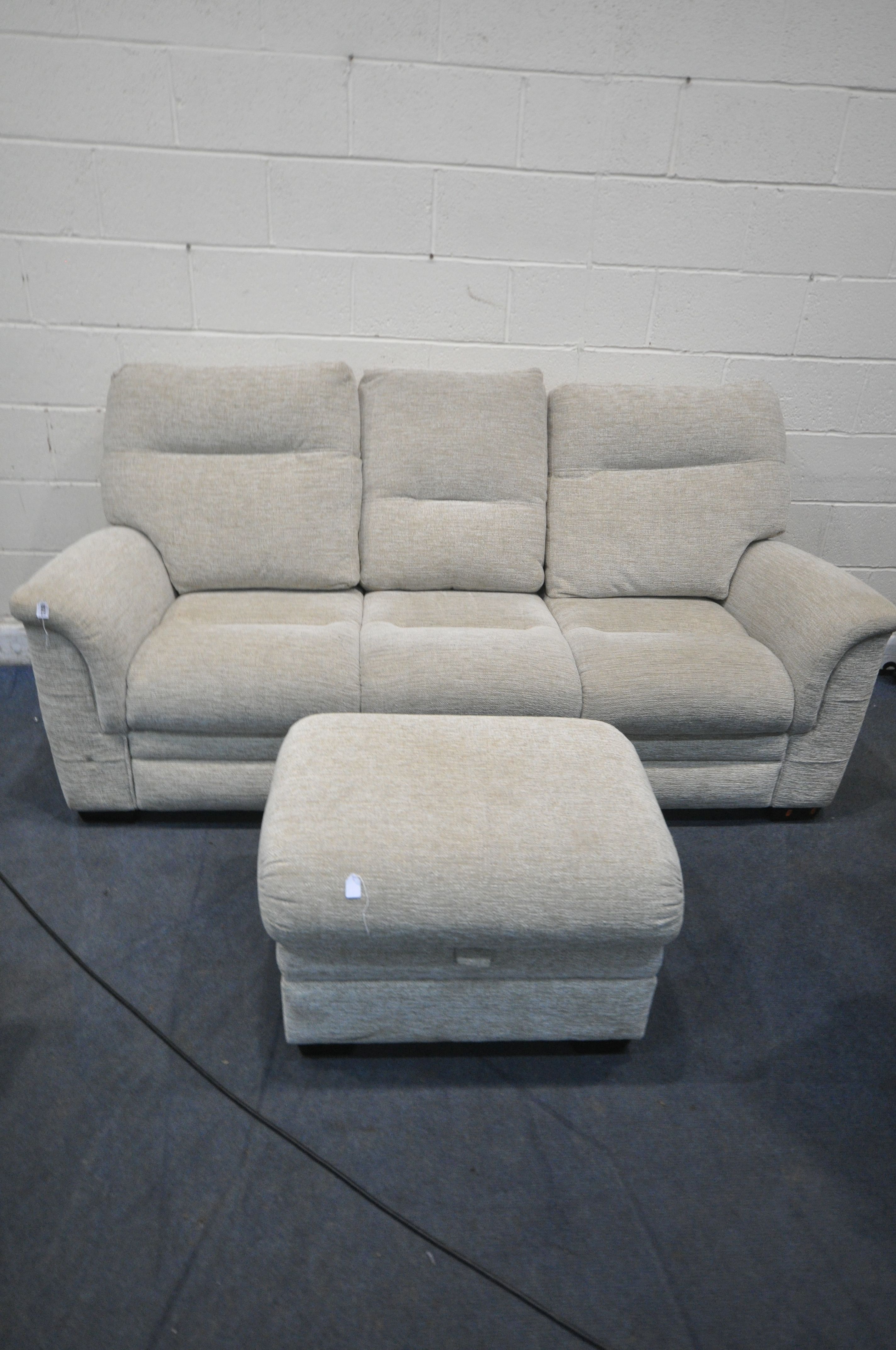 A CREAM UPHOLSTERED PARKER KNOLL THREE SEATER SOFA, length 206cm, and a matching footstool (
