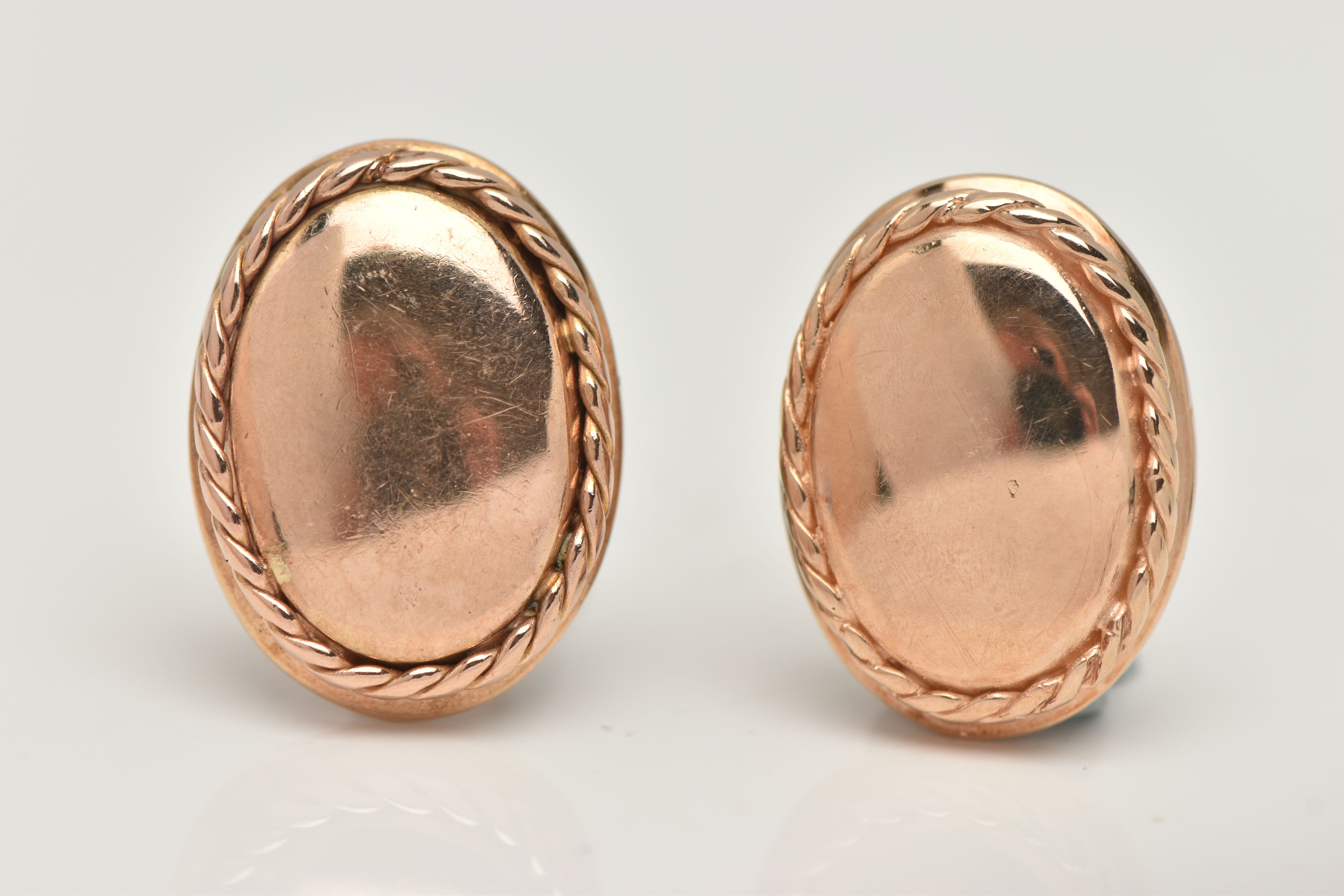 A PAIR OF YELLOW METAL CLIP ON EARRINGS, each of a polished oval form with rope twist surround,