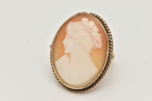A YELLOW METAL CAMEO RING, large oval carved shell cameo depicting a lady in profile, collet set