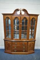 A LATE 20TH CENTURY HARDWOOD BOOKCASE, the twin swan neck pediment, flanking a finial, four glazed