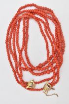 A CORAL BEAD NECKLACE, triple strand of round polished graduated coral beads, fitted with a yellow