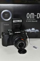 A BOXED OLYMPUS OM-D E-M10 III WITH A 14-42 F3.5-5.6 ZOOM LENS, together with an Olympus battery,