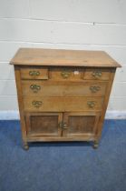 AN EARLY 20TH CENTURY OAK CABINET, fitted with five assorted drawers, above double cupboard doors,