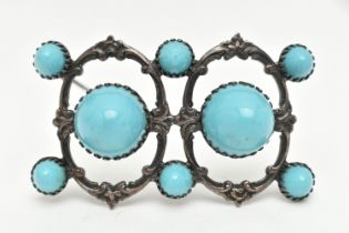 A WHITE METAL BROOCH, open work brooch set with two large blue ceramic domes and six smaller