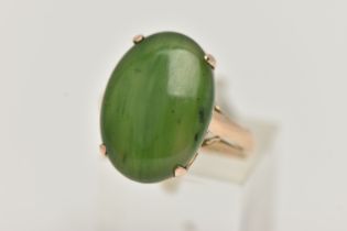 A YELLOW METAL, NEPHRITE CABOCHON RING, of an oval form, nephrite measuring approximately length