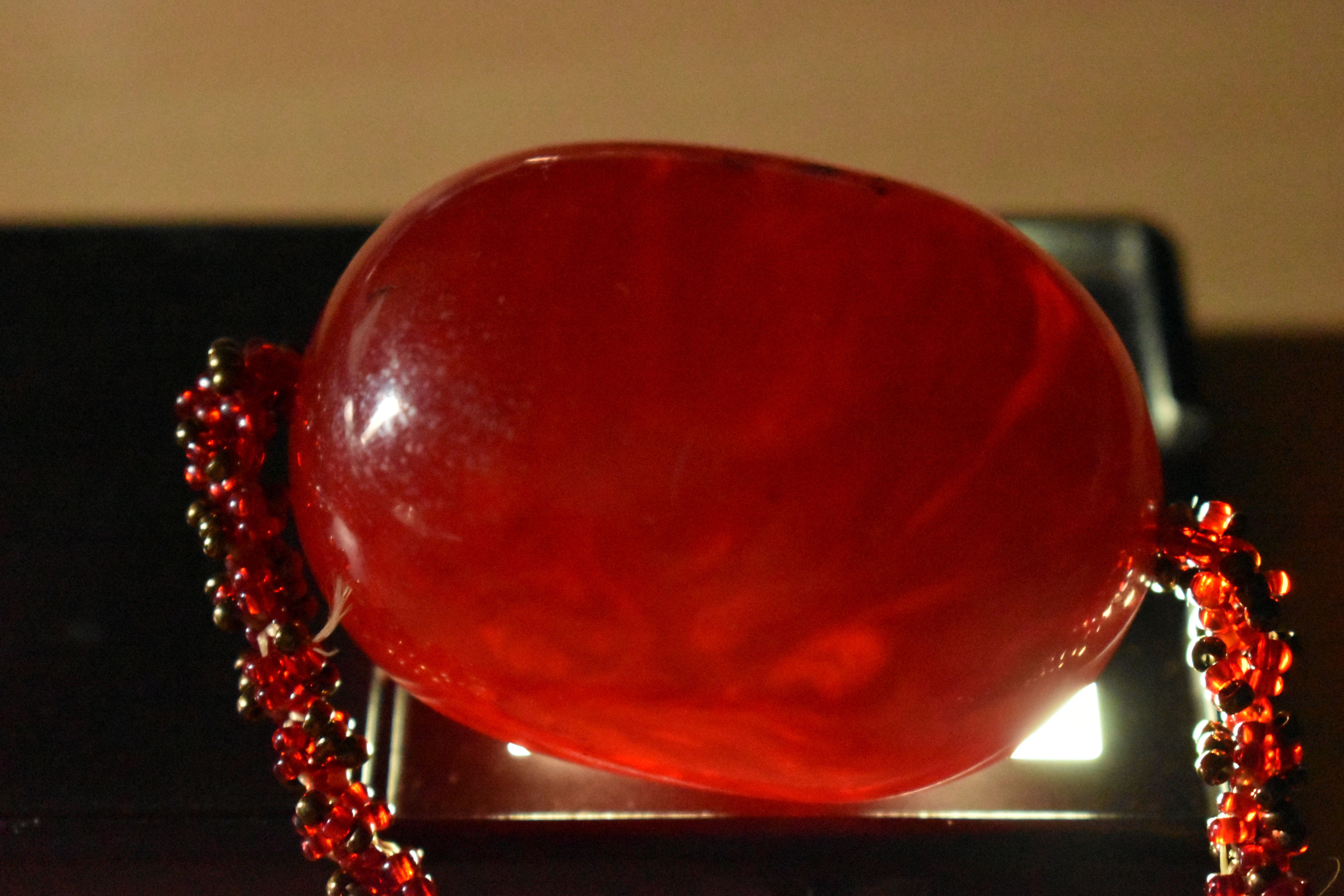 A SMALL BAG OF ITEMS, to include a large oval cherry amber colour Bakelite bead fitted on a red - Image 7 of 7