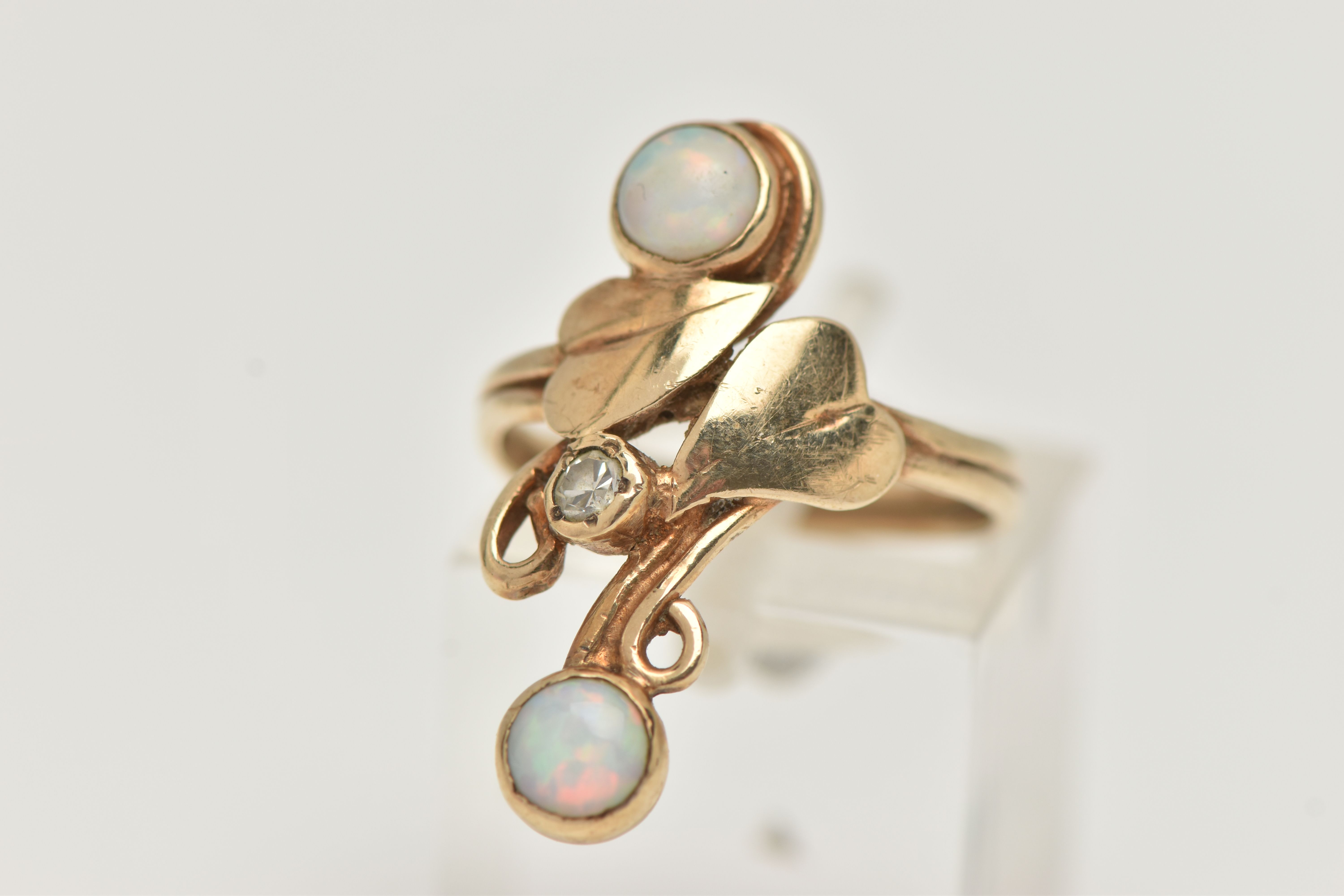 A 9CT GOLD OPAL AND DIAMOND RING, the up finger ring with central single cut diamond and foliate