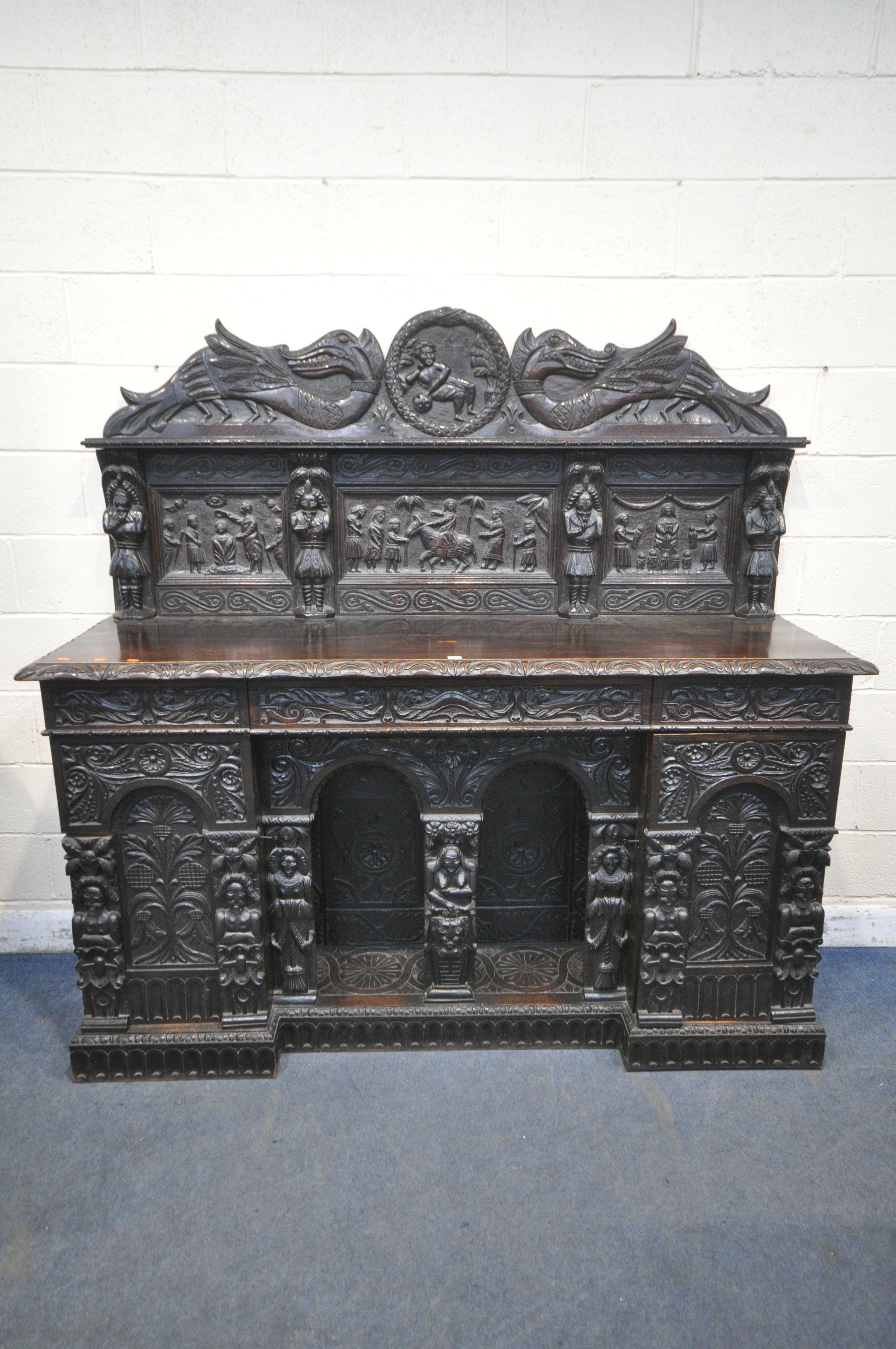 A 19TH CENTURY HEAVILY CARVED OAK SIDEBOARD, the raised back with panelling and shelf, fitted with
