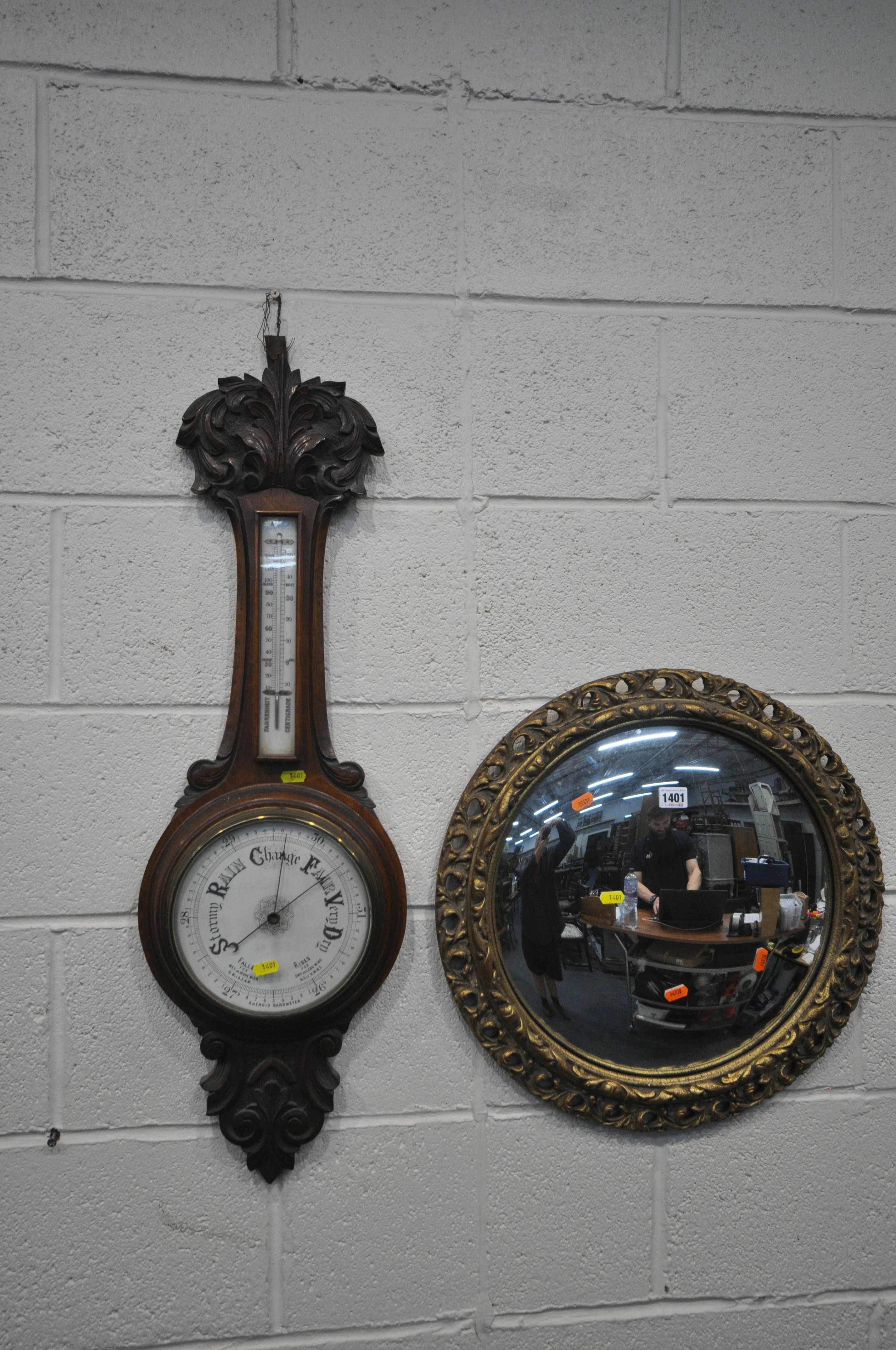 A CIRCULAR GILT FRAMED CONVEX WALL MIRROR, diameter 52cm, along with a carved oak barometer (