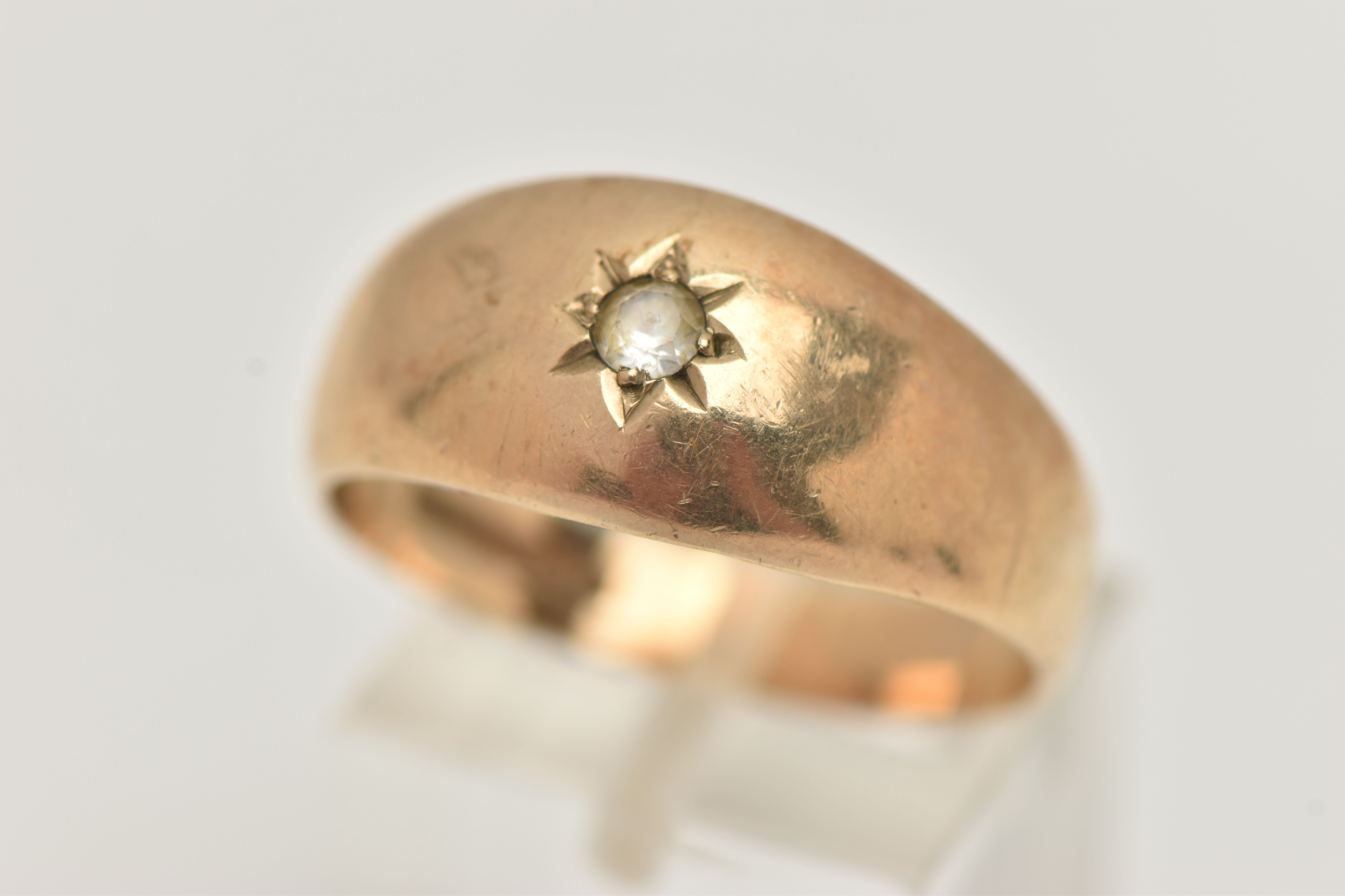 A GENTS 9CT GOLD SIGNET RING, set with a circular cut colourless spinel, in a star setting, polished
