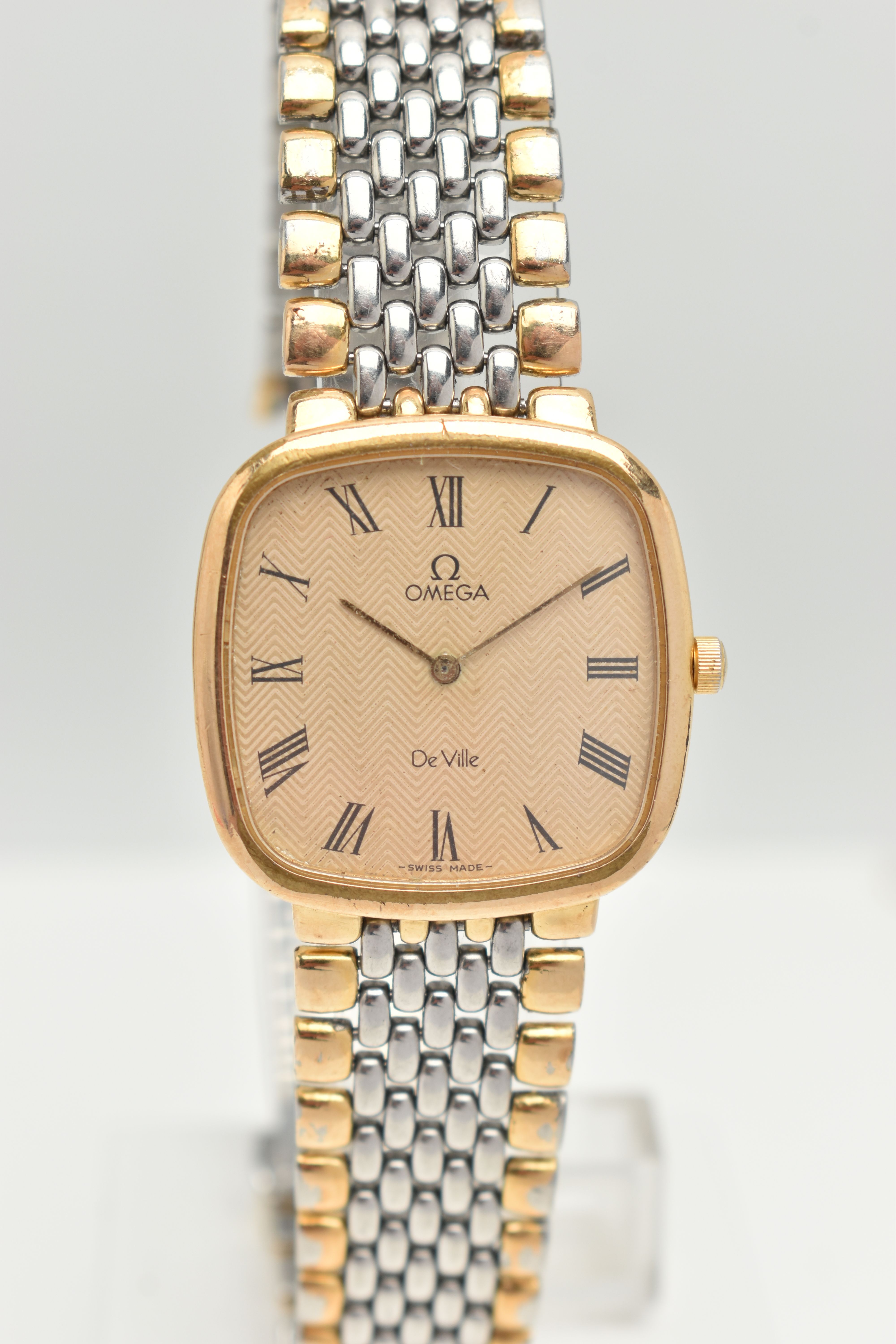 AN OMEGA DE VILLE STAINLESS STEEL WRISTWATCH, the curved square face with black Roman numerals, gold