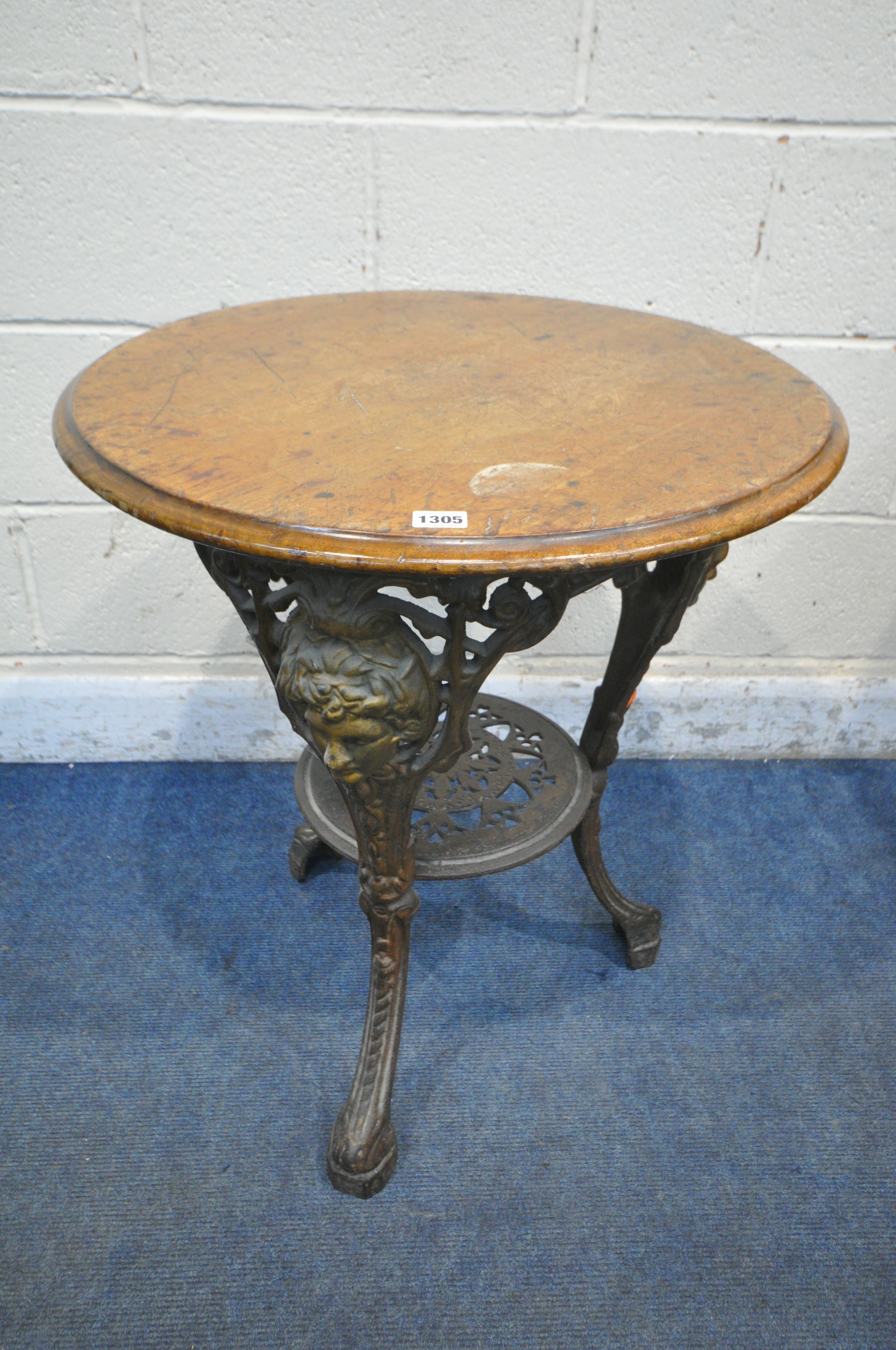 A CAST IRON CIRCULAR PUB TABLE, with a walnut top, diameter 61cm x height 70cm (condition report: