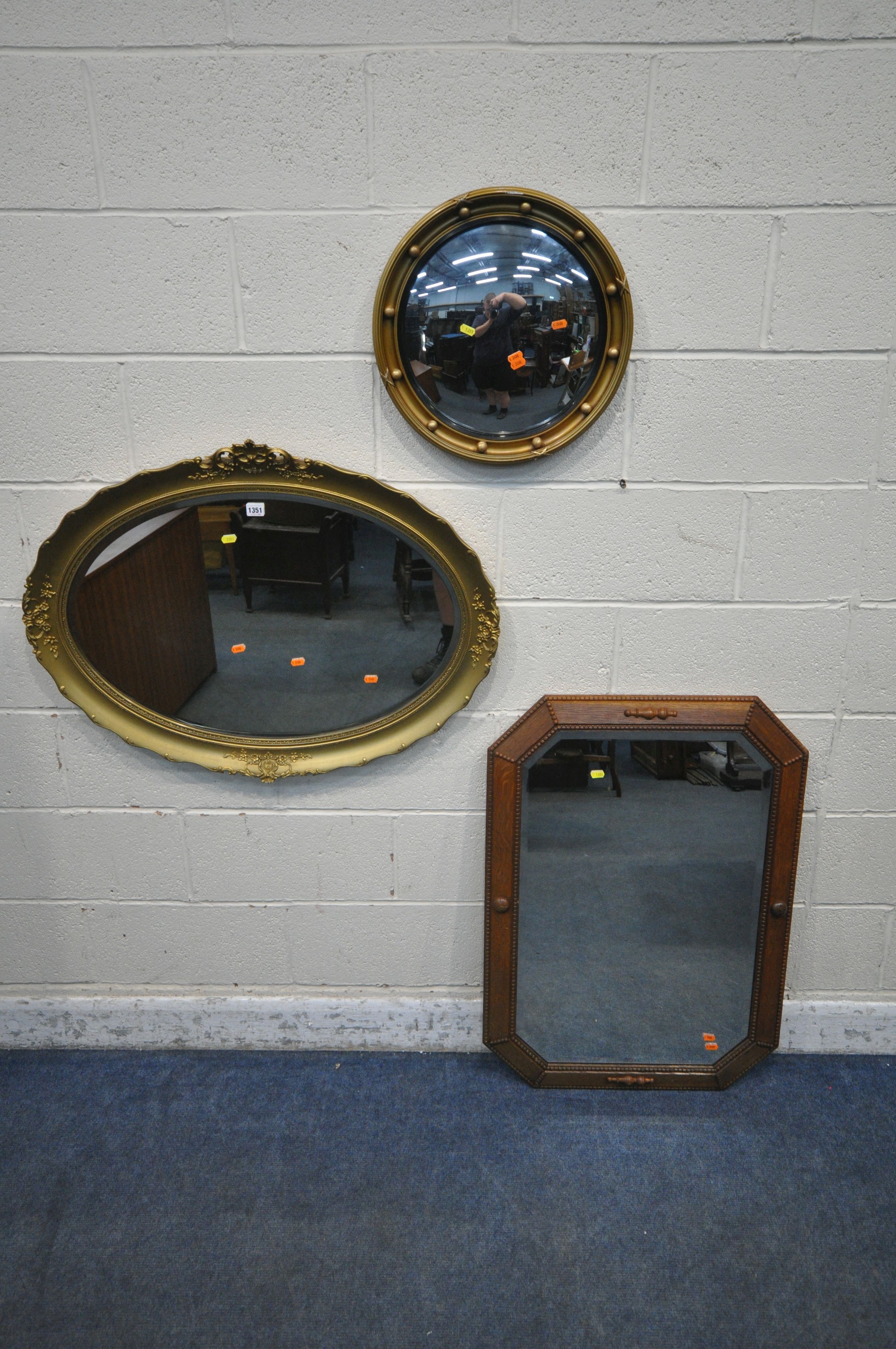 A GILT RESIN OVAL BEVELLED EDGE WALL MIRROR, with foliate details, 90cm x 69cm, a Regency style