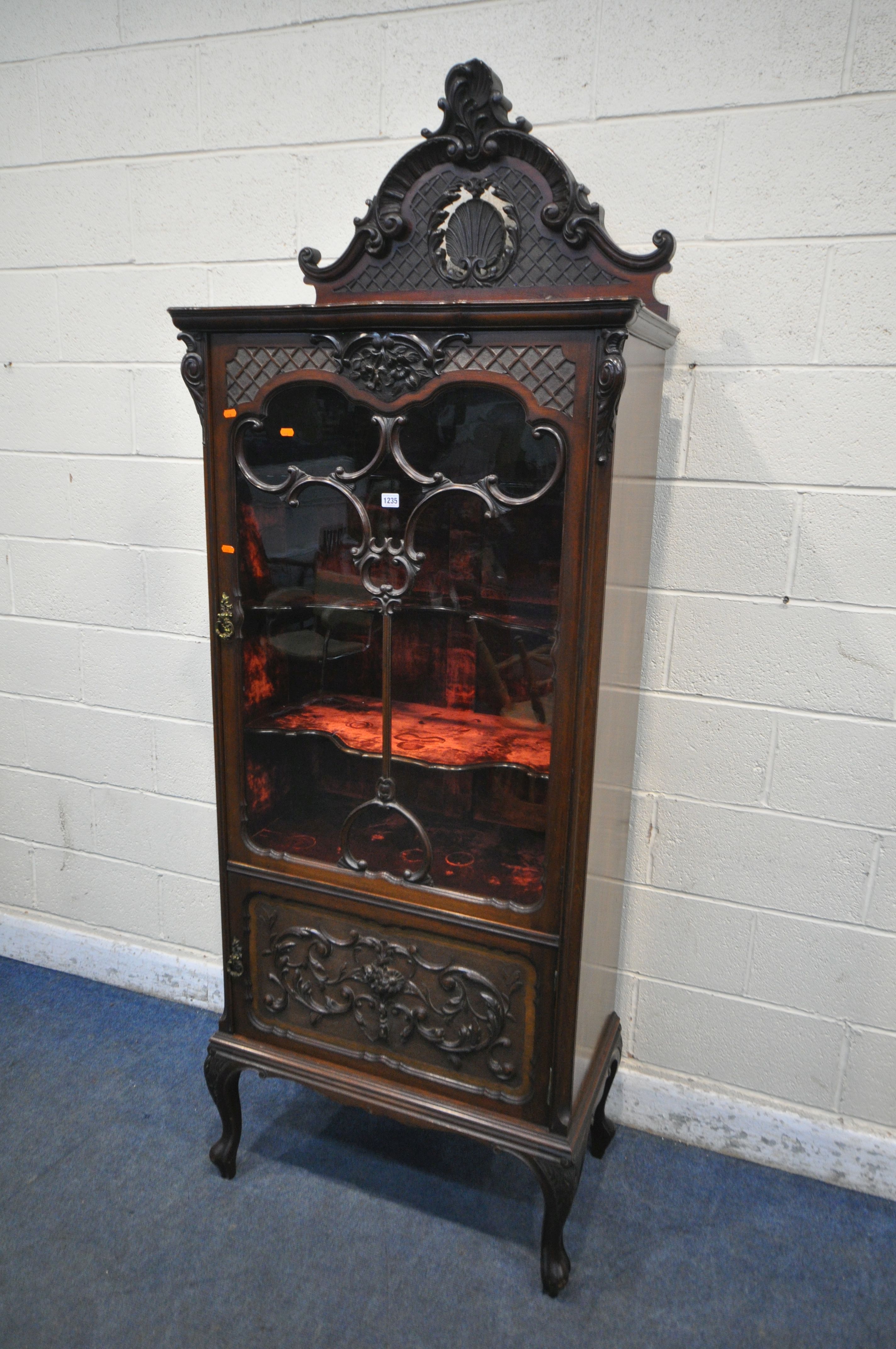 AN EARLY 20TH CENTURY MAHOGANY SINGLE DOOR CABINET, with a triple shaped shelves, and red velvet