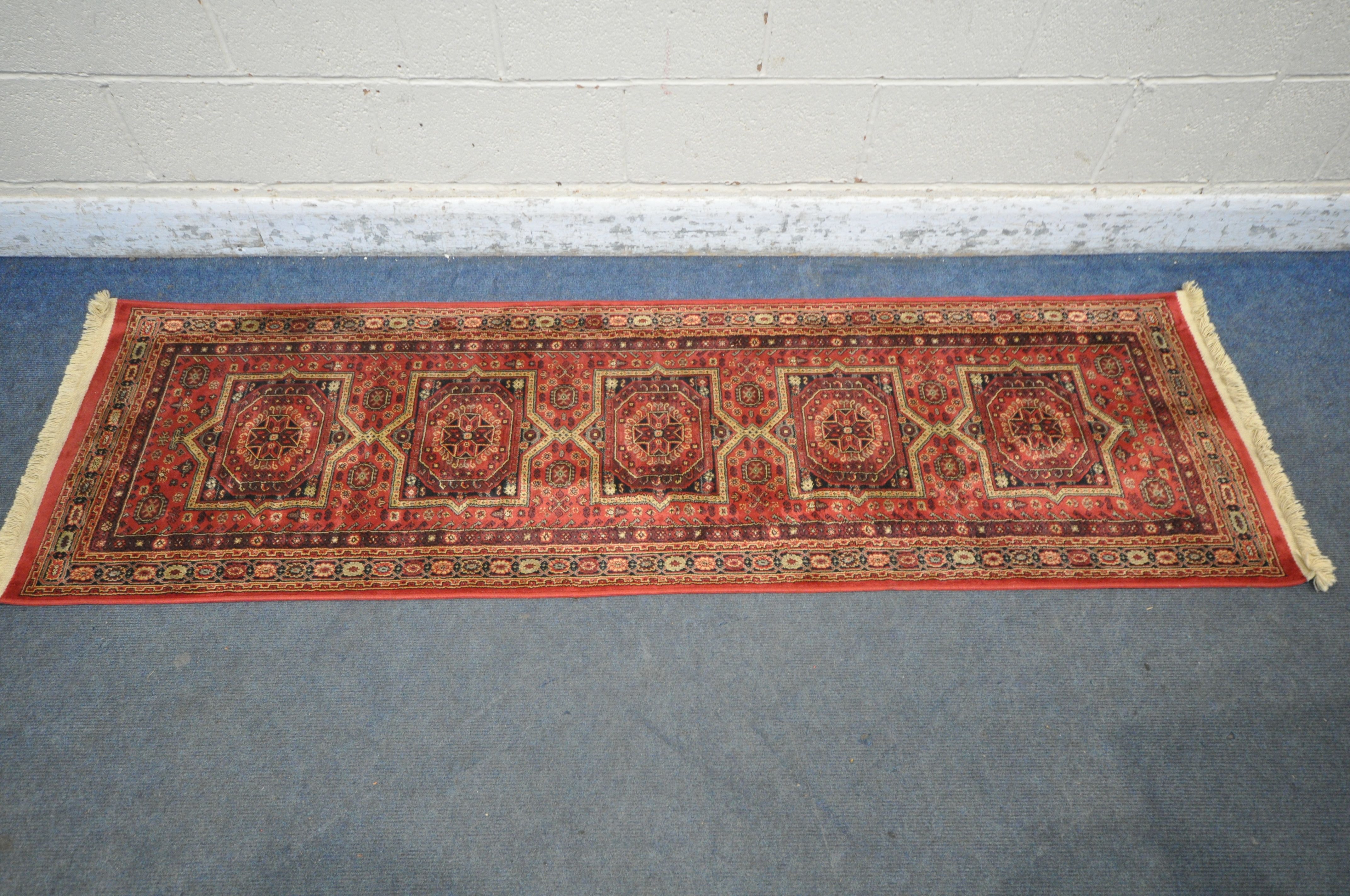 A LATE 20TH CENTURY SYNTHETIC RED PATTERNED CARPET RUNNER, 210cm (condition report: good)
