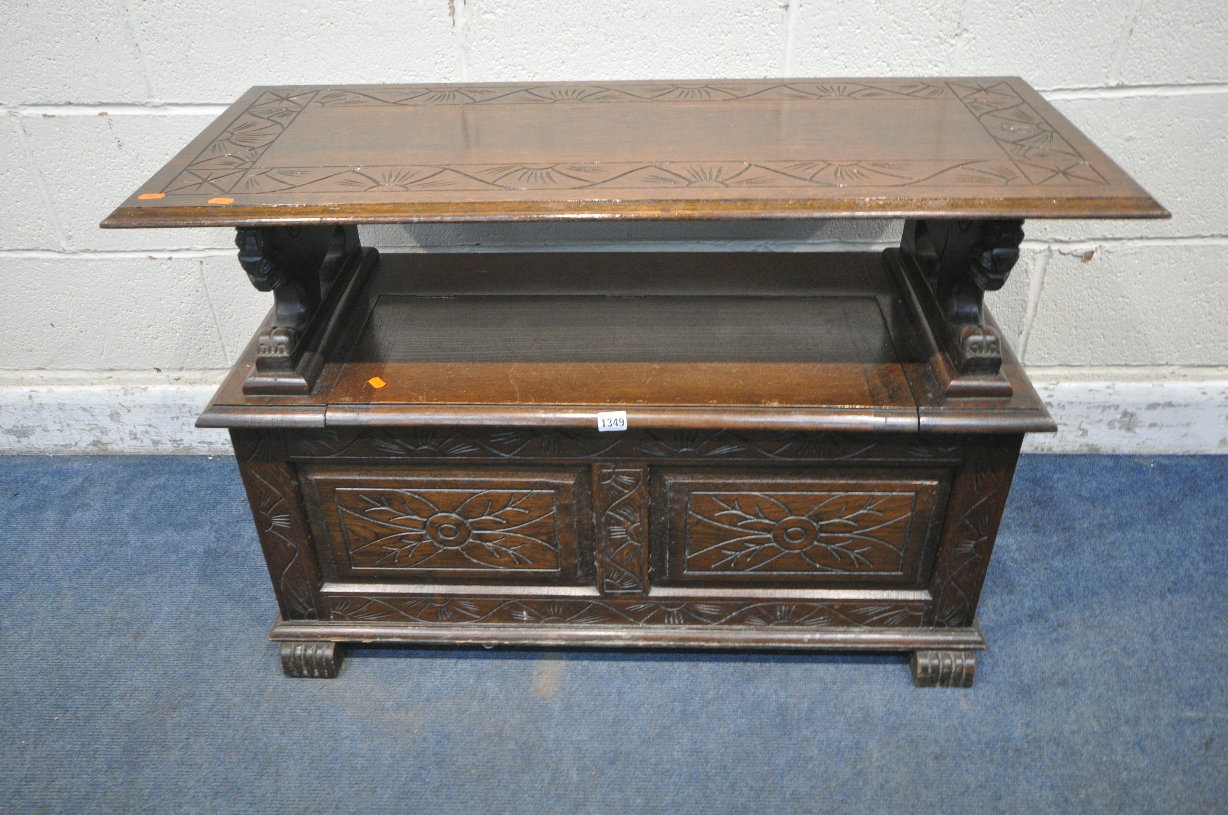 AN EARLY 20TH CENTURY OAK MONKS BENCH, with a rise and fall backrest / surface, lion armrests and