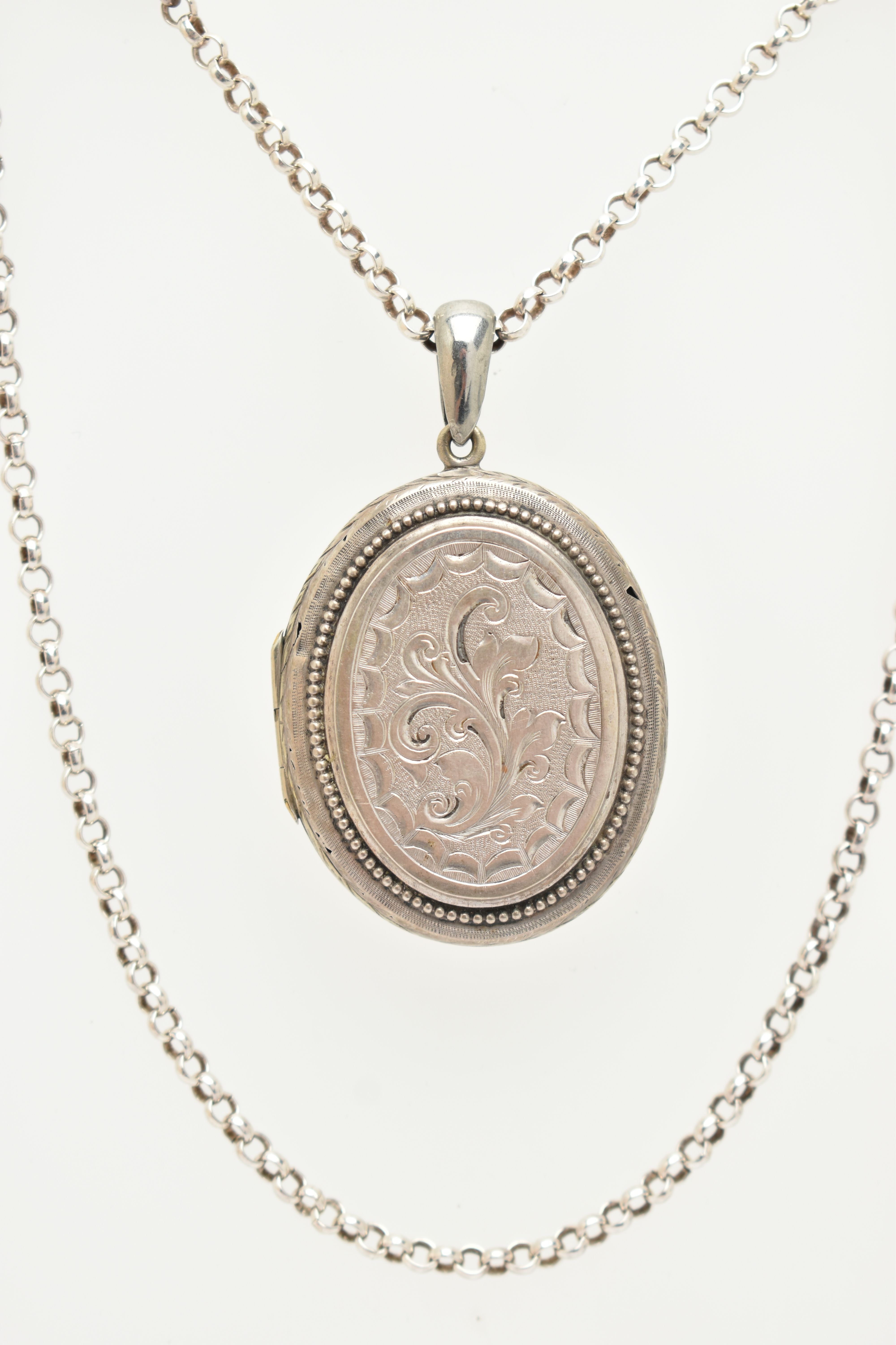 A LOCKET AND A CHAIN, a base metal oval locket with embossed floral and acanthus detail, together