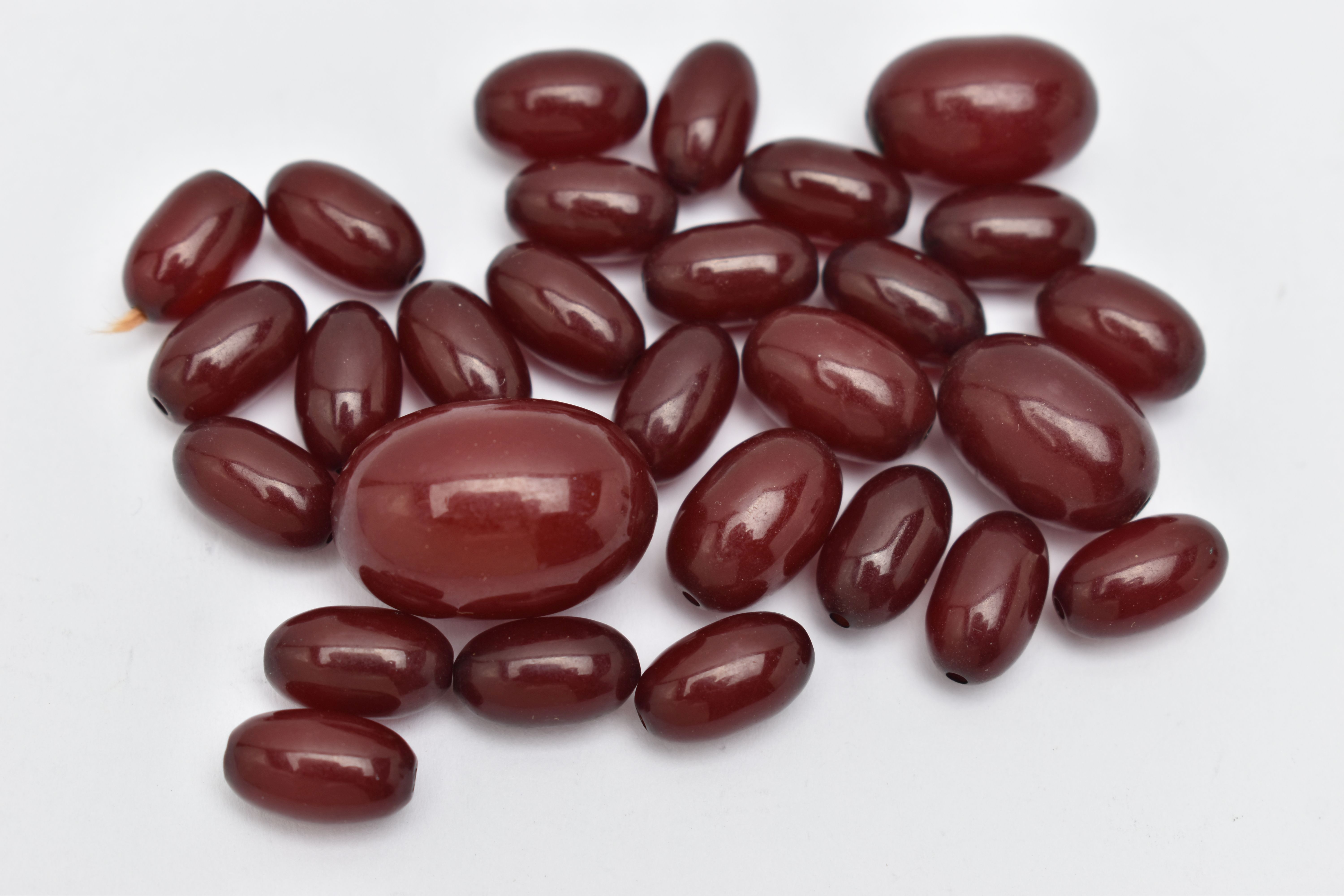 A SMALL QUANTITY OF CHERRY AMBER COLOUR BAKELITE BEADS, loose beads of an oval form, largest - Image 2 of 6