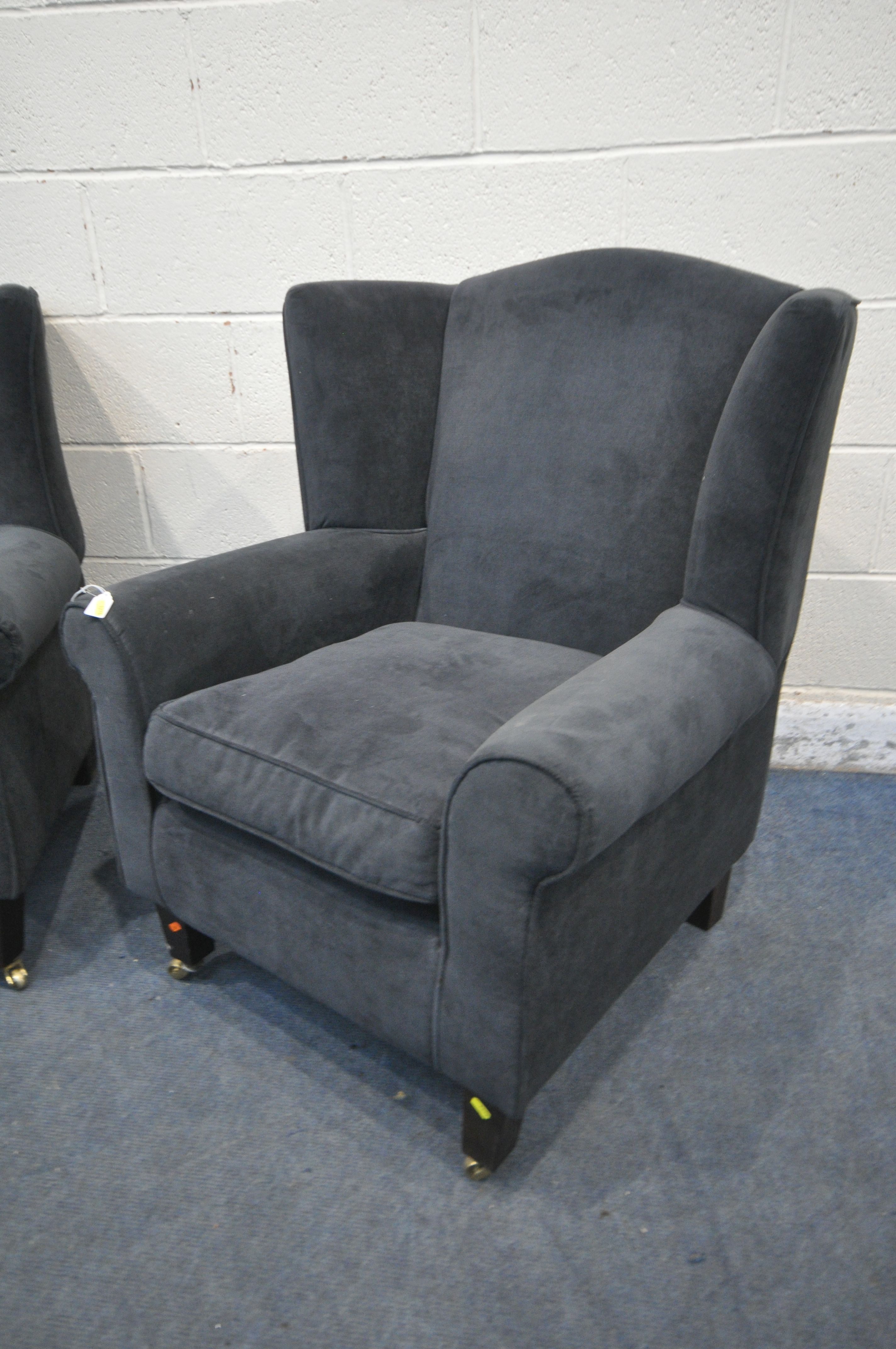 A PAIR OF DARK BLUE UPHOLSTERED ARMCHAIRS, along with a brown footstool (condition report: in need - Image 2 of 3