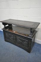 AN EARLY TO MID 20TH CENTURY DARK OAK MONKS BENCH, with lion armrests, flanking a hinged storage