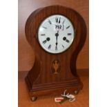 AN EDWARDIAN MAHOGANY BALLOON SHAPED MANTEL CLOCK, oval inlay with trophy, enamel dial with Roman