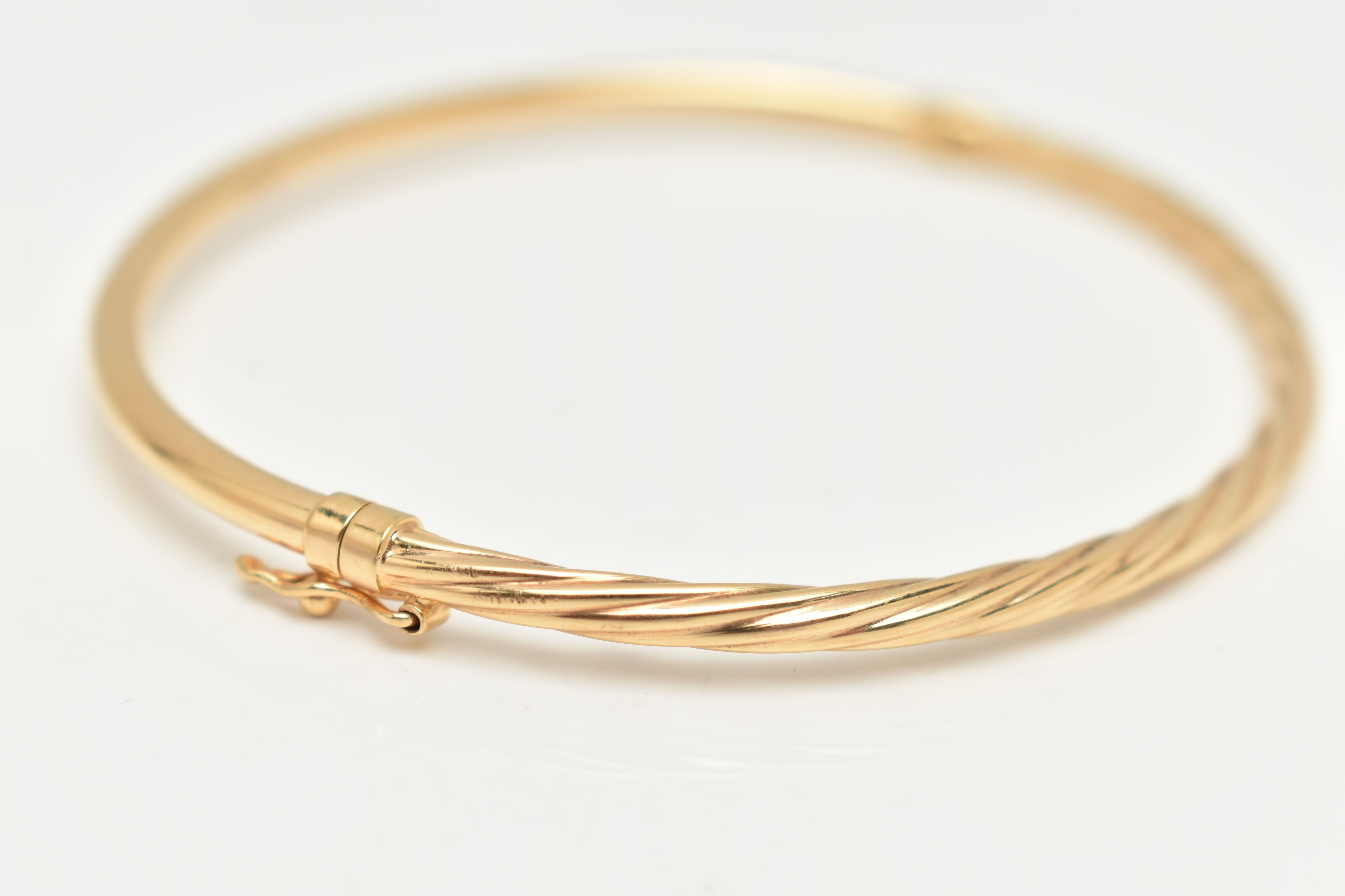 A YELLOW METAL TWIST HINGED BANGLE, part twisted part polished hinged bangle, stamped 375, fitted - Image 2 of 3