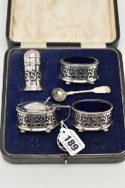 A CASED GEORGE V SILVER FOUR PIECE CRUET SET WITH FOLIATE PIERCED DECORATION, comprising oval