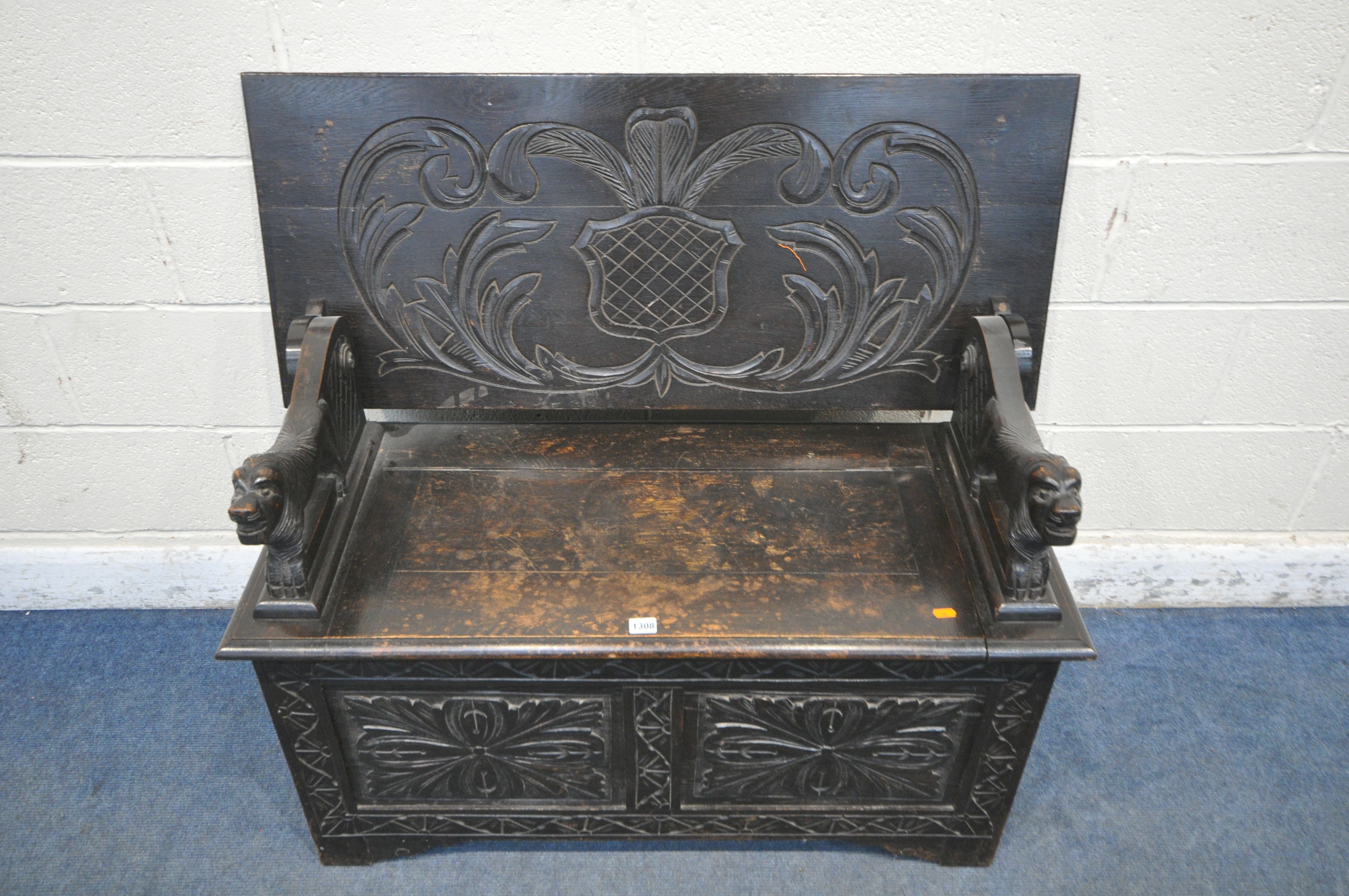 AN EARLY TO MID 20TH CENTURY DARK OAK MONKS BENCH, with lion armrests, flanking a hinged storage - Image 3 of 4