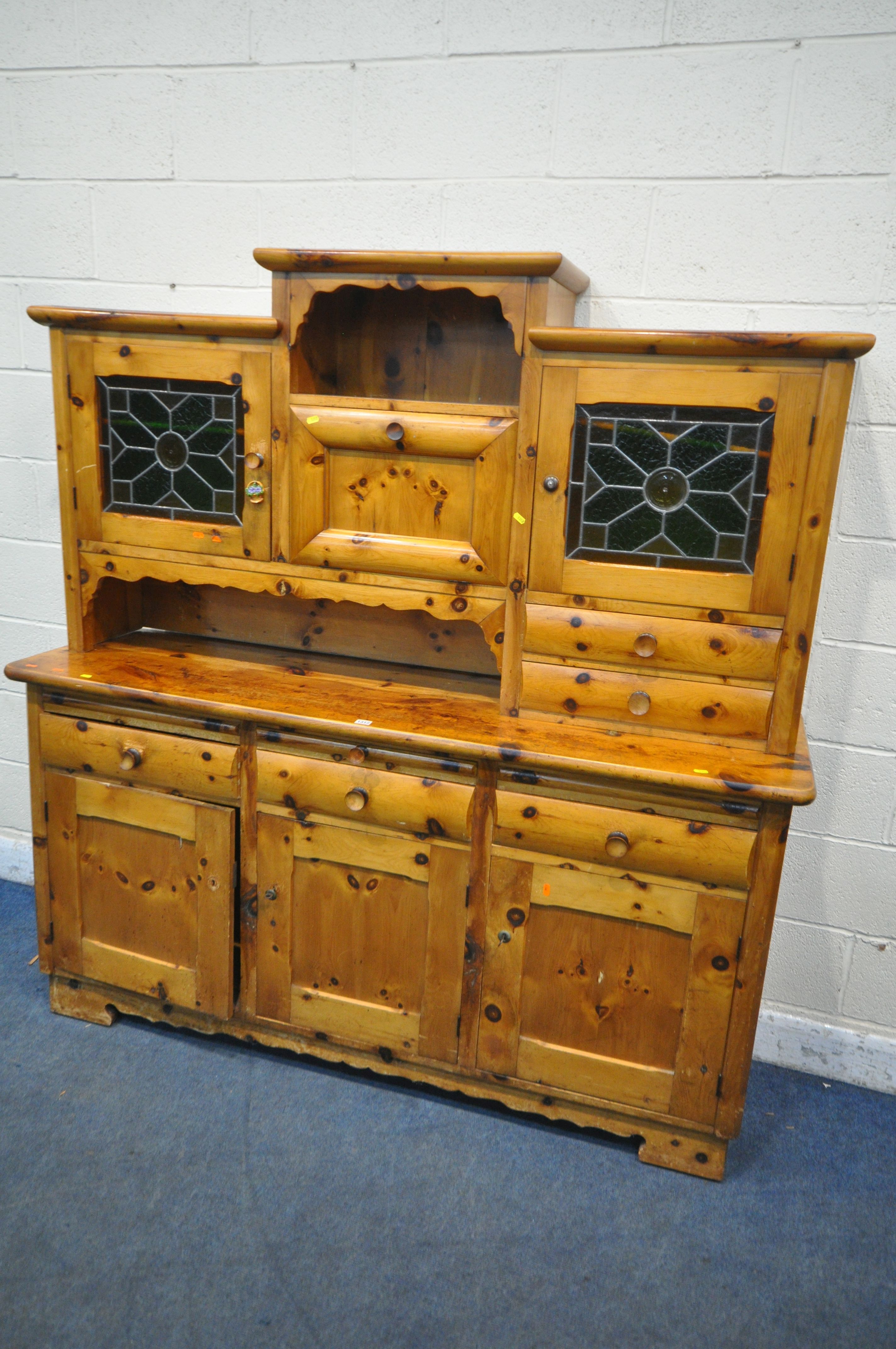 A PINE DRESSER, the top made up in an arrangement of drawers and cupboard, above a base with three