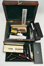 A WOODEN BOX WITH ASSORTED PENS, a hinged wooden box encasing a selection of fountain pens, names to